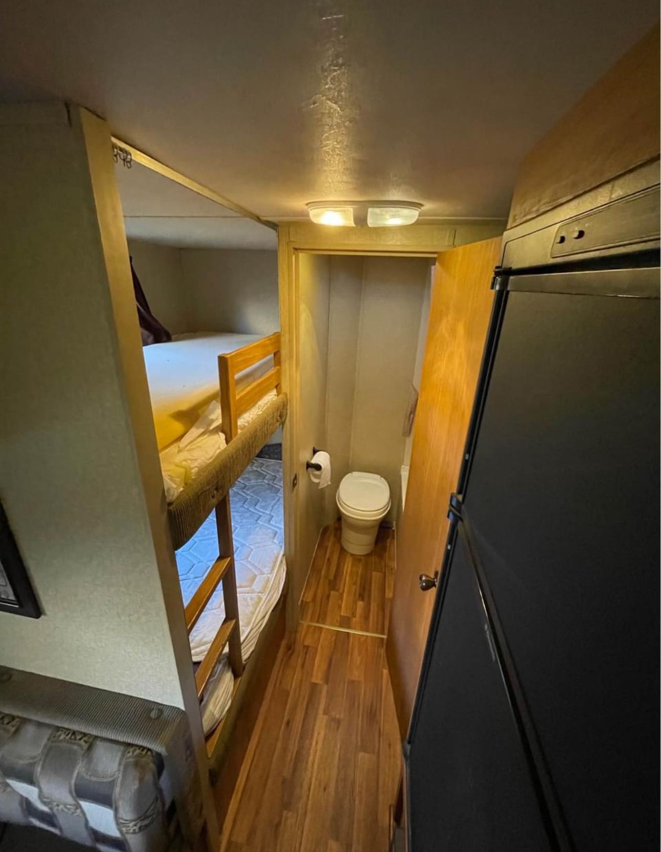 RV rental interior: Features a compact bathroom with a toilet, bunk beds to the left, and a refrigerator on the right.. Forest River Salem Cruise Lite 2010