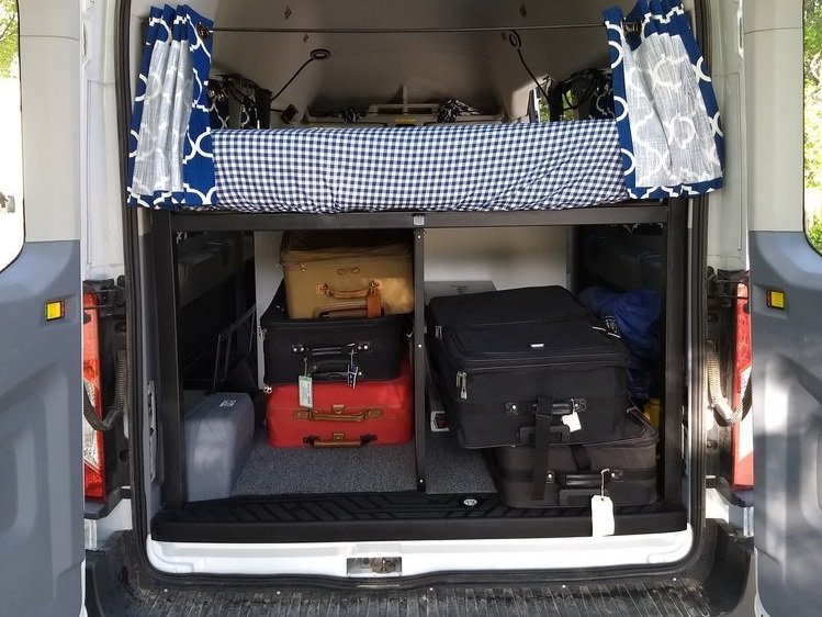 Organized RV rental van. Elevated bed over luggage storage maximized for travel convenience.. Mercedes-Benz Sprinter 2019