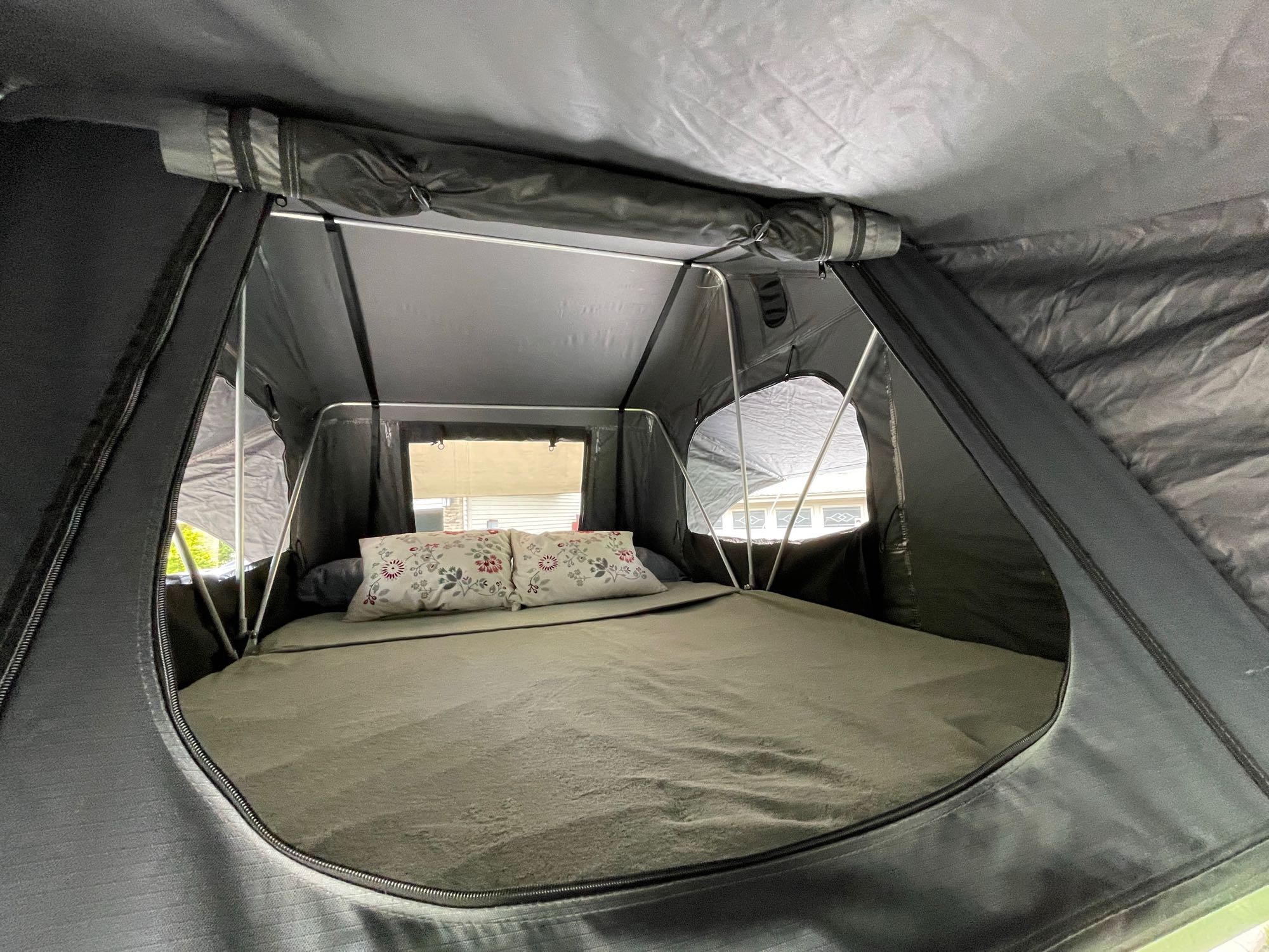 Comfortable rooftop tent interior for RV rental. Ideal camping setup with bed & pillows.. Nutshell Campers Nutshell Camper 2025