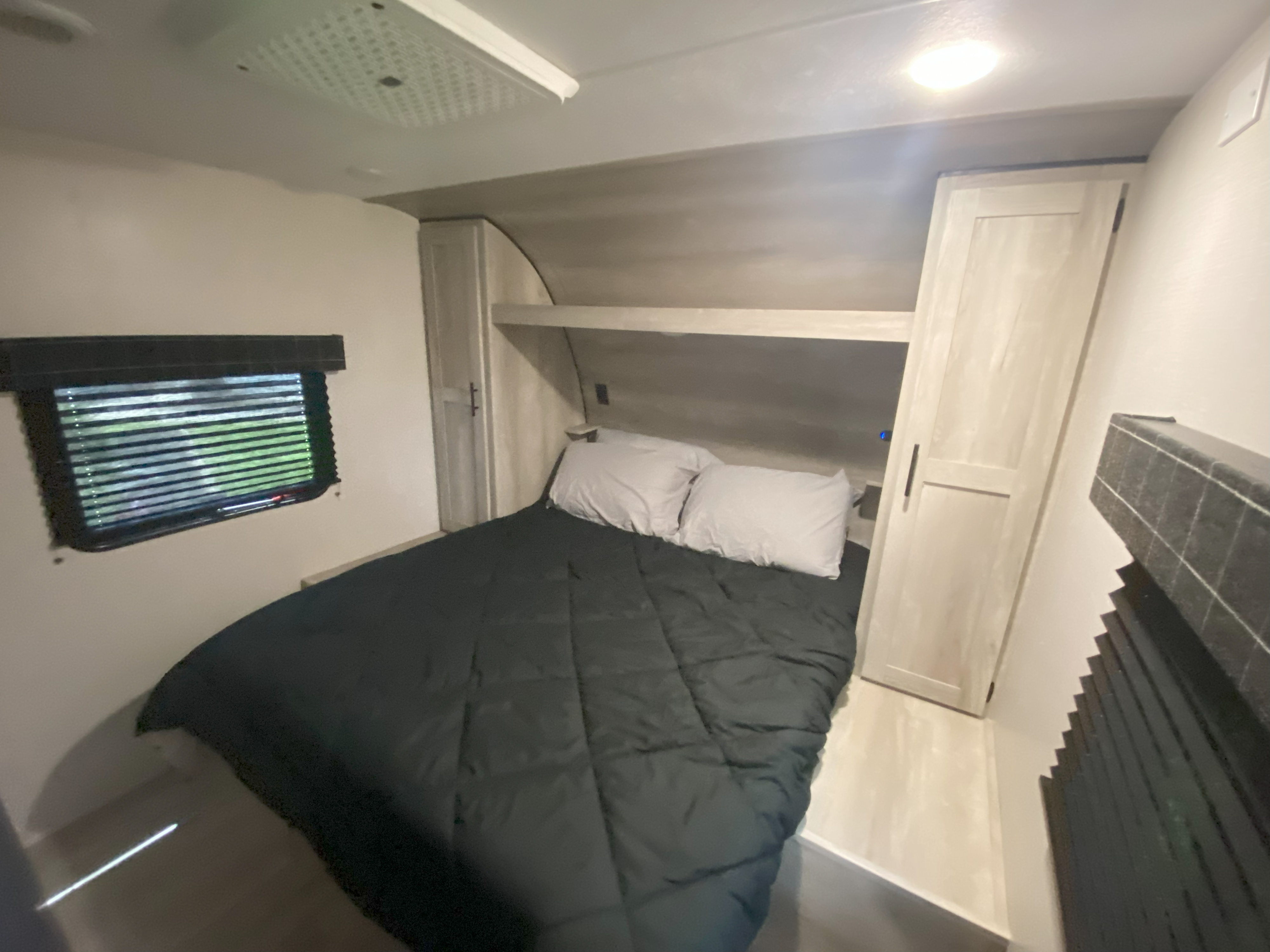 Cozy RV rental bedroom featuring a bed, window, and built-in storage. Ideal for travel trailer adventures.. K-Z 4eztu282xr5090260 2024