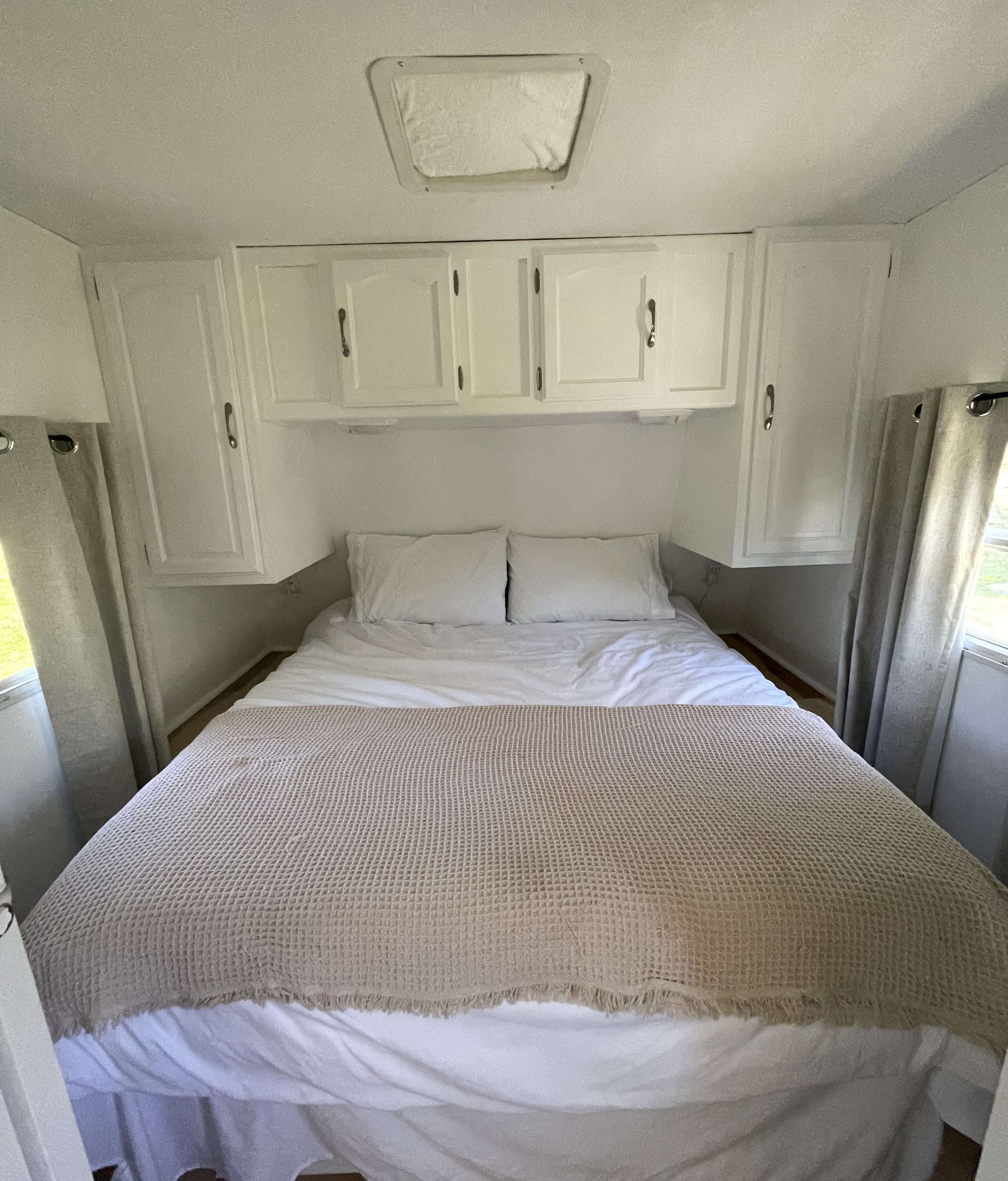 Cozy RV rental bedroom with white decor, ample storage, and natural light. Perfect for comfortable travel.. Keystone RV Copper Canyon 2006