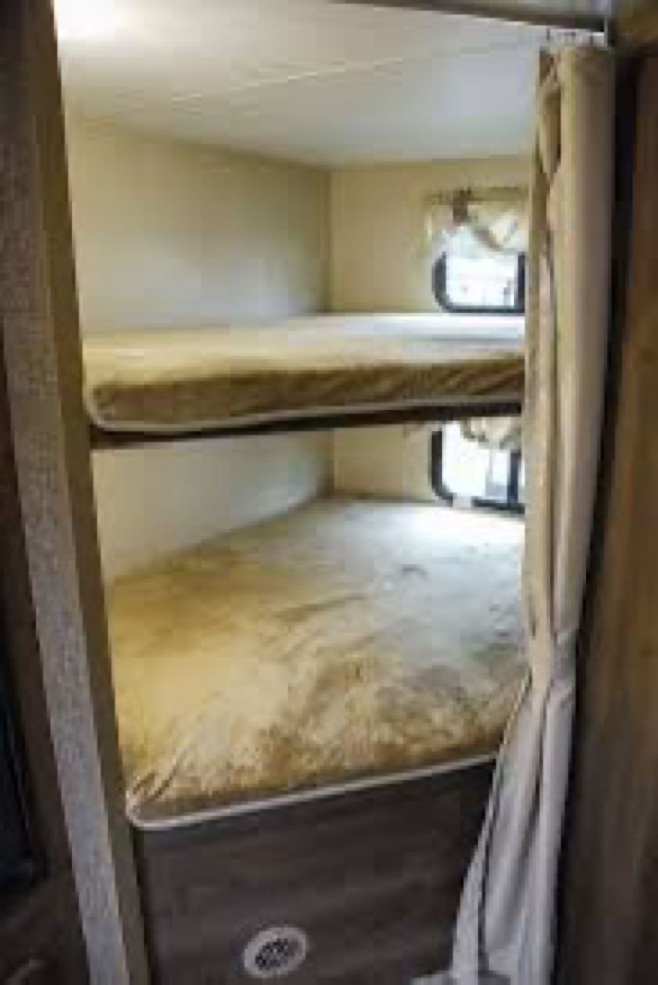 Cozy RV rental interior features bunk beds with windows and a privacy curtain.. KZ Connect 214bhk 2018