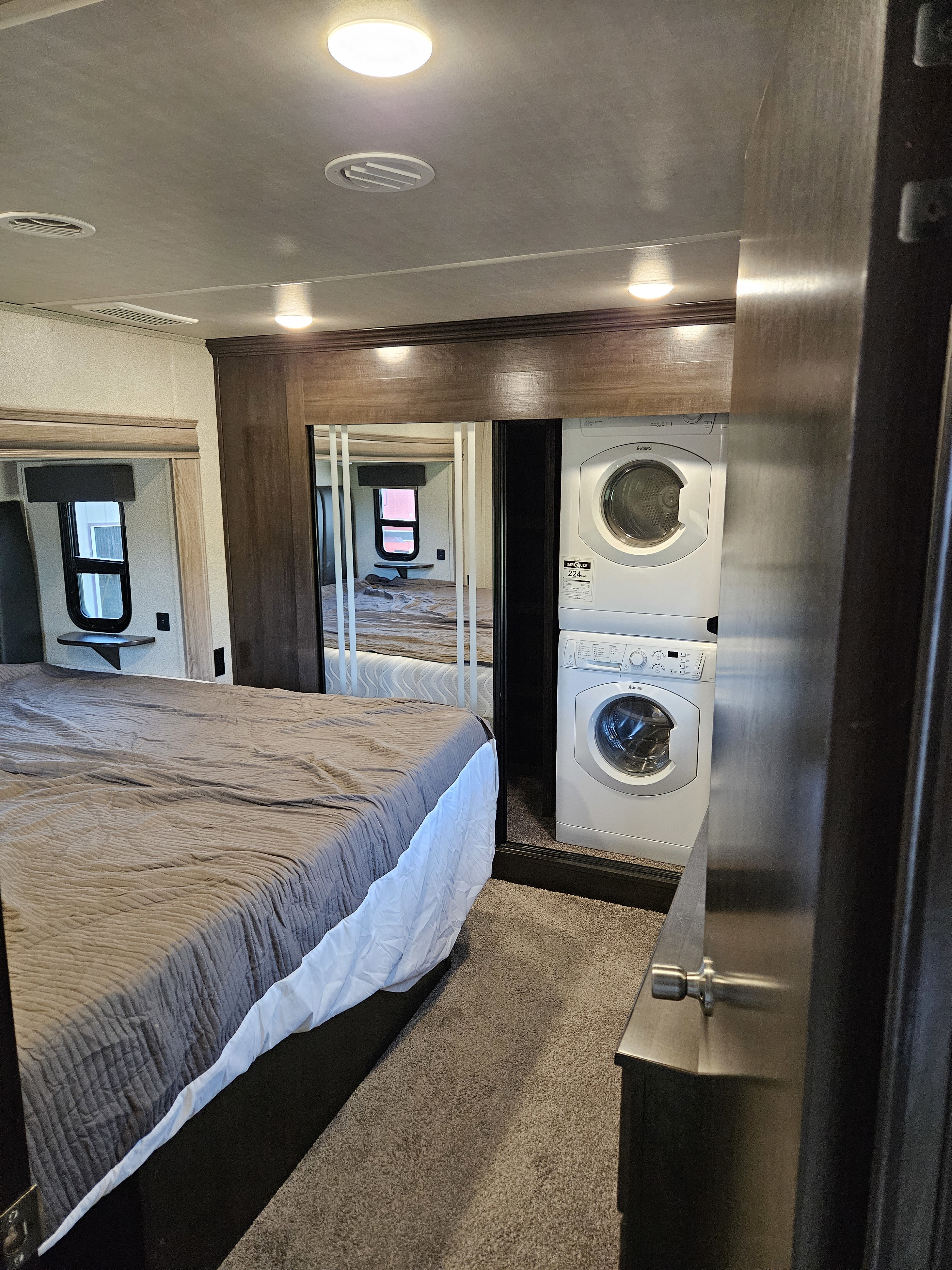 Spacious RV rental bedroom with a comfy bed, mirrored closet, and convenient in-unit washer and dryer.. Cedar Creek Silverback 2020