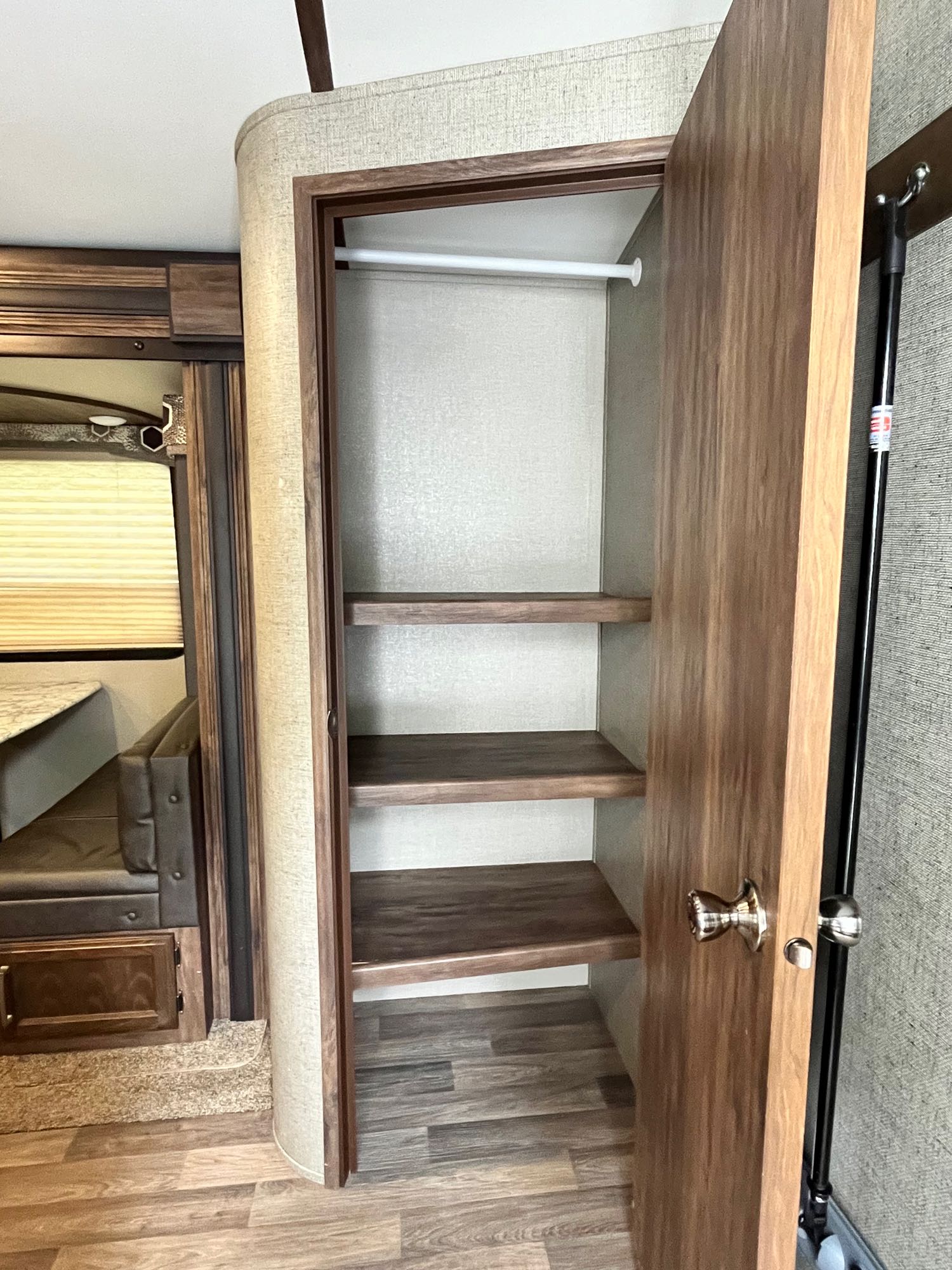 RV rental interior: open closet with shelves & hanging rod for storage, next to a comfy dinette.. Keystone RV Cougar X-Lite 2018