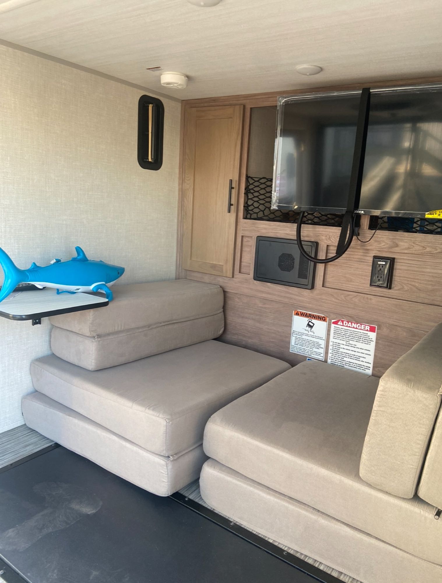RV rental interior featuring modular seating, a wall-mounted TV, cabinets, and a compact layout.. Forest River NOBO 10.6 2022