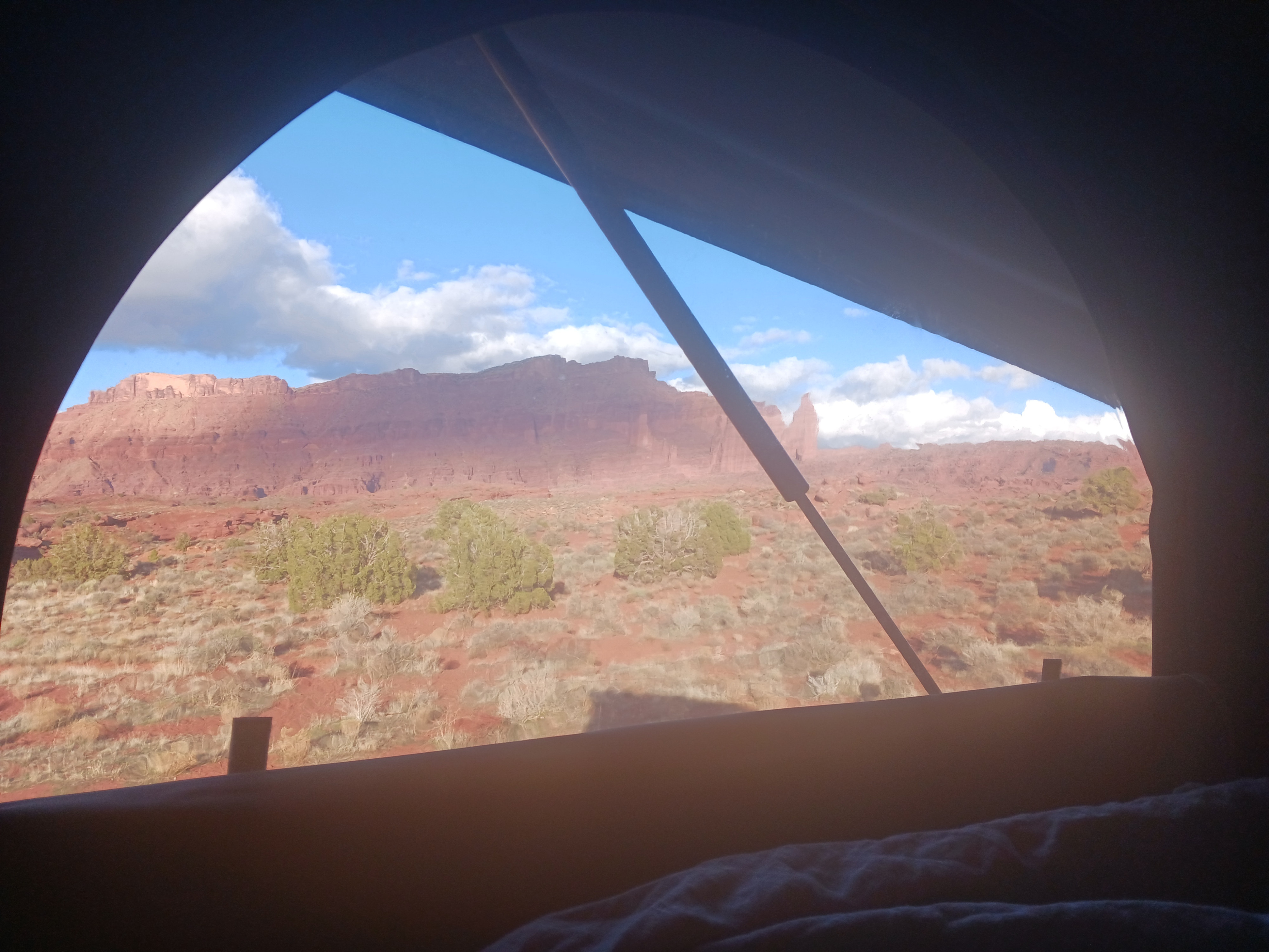Awake to a striking red rock desert view from a tent, part of an unforgettable RV rental experience.. Mercedes-Benz Sprinter 2023