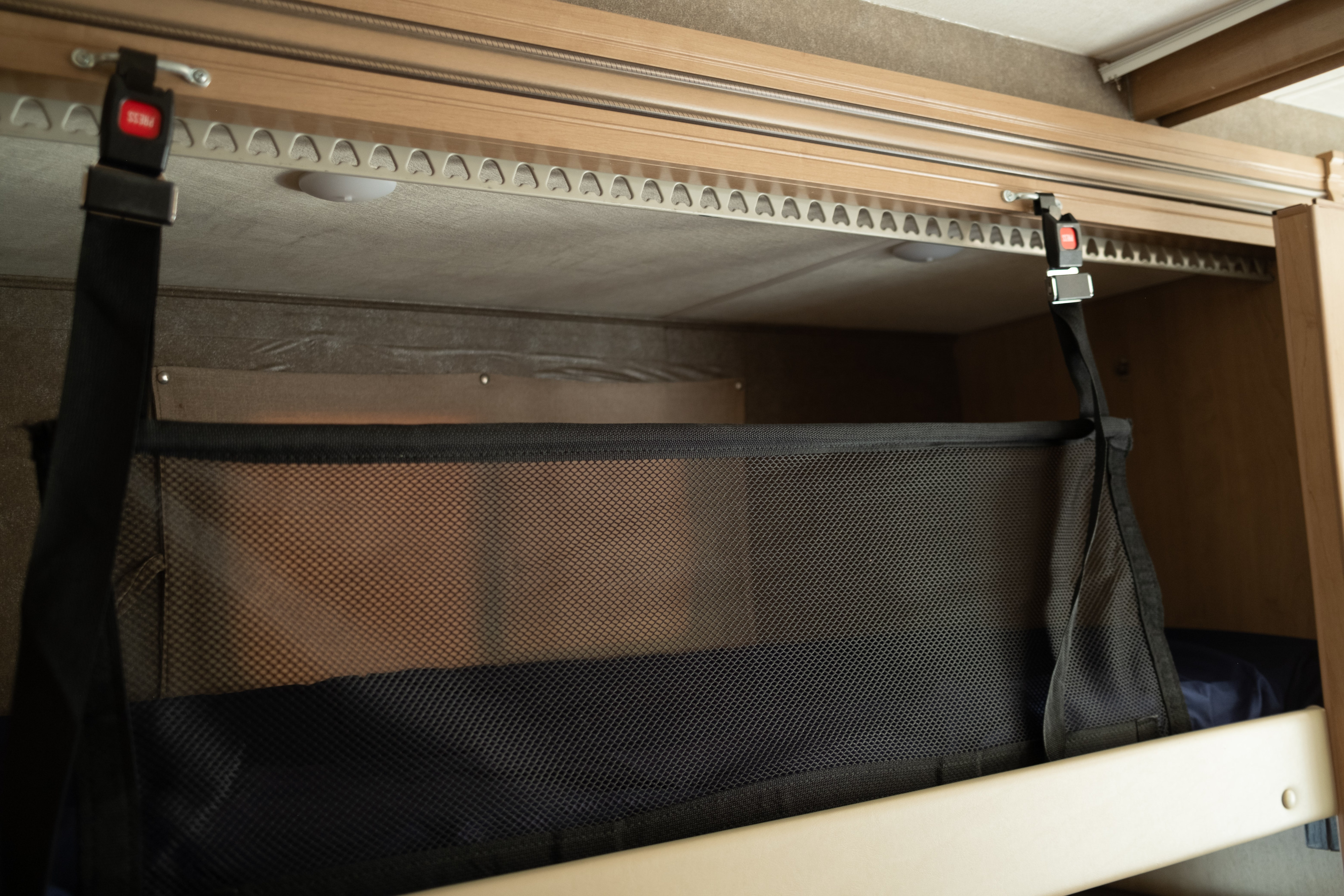 RV rental bunk bed with mesh safety net and buckle system, ensuring secure sleeping.. Thor Four Winds 2021