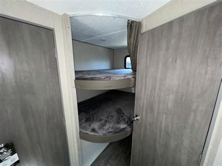 RV rental interior: two stacked bunk beds visible in a cozy alcove between two doors. Ideal for camper accommodation.. Forest River Aurora Aurora Light 2024