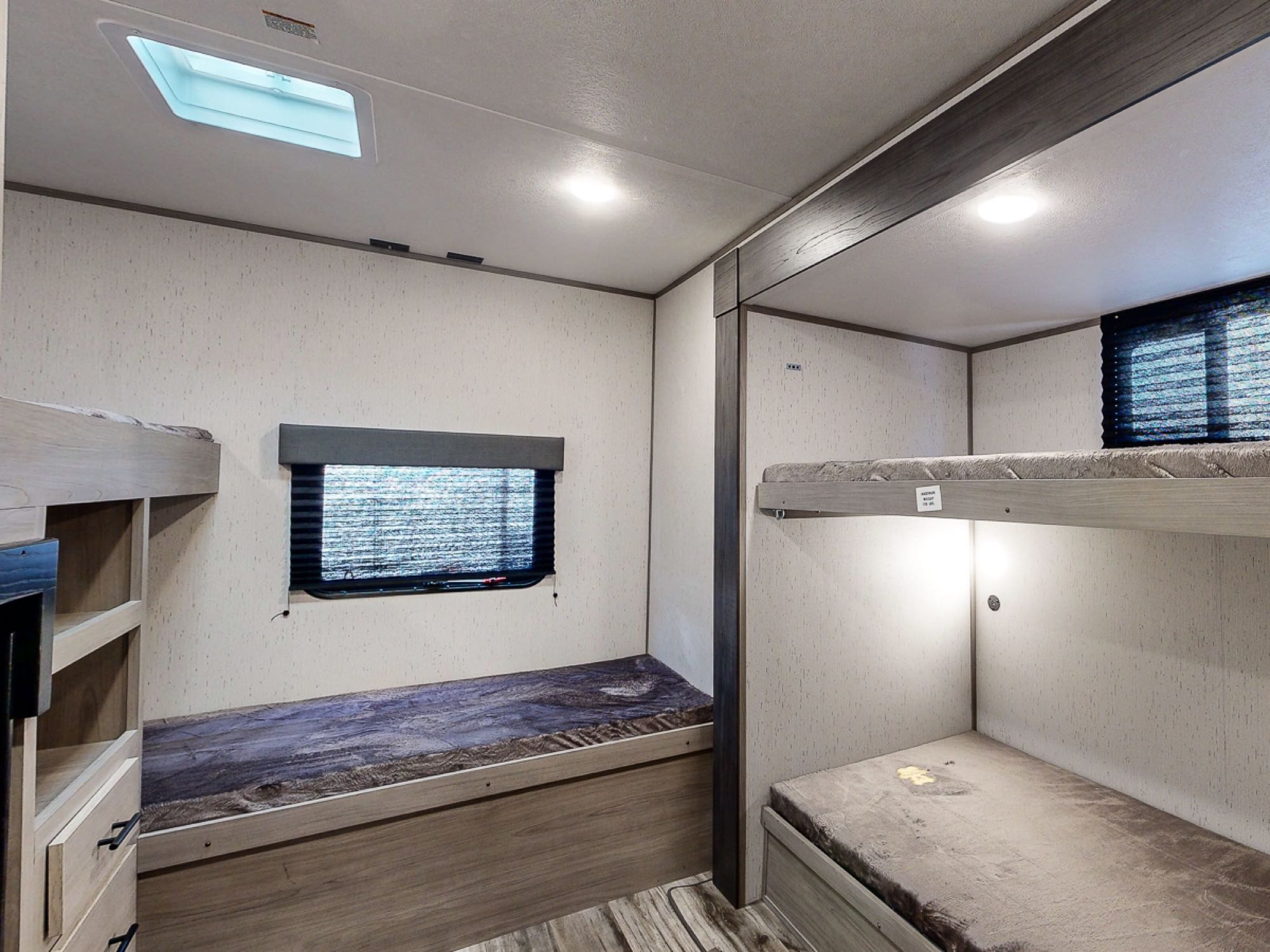 RV rental bunk beds feature: Bright interior with skylight, window, and cozy sleeping spaces.. Dutchmen Coleman Lantern 2022