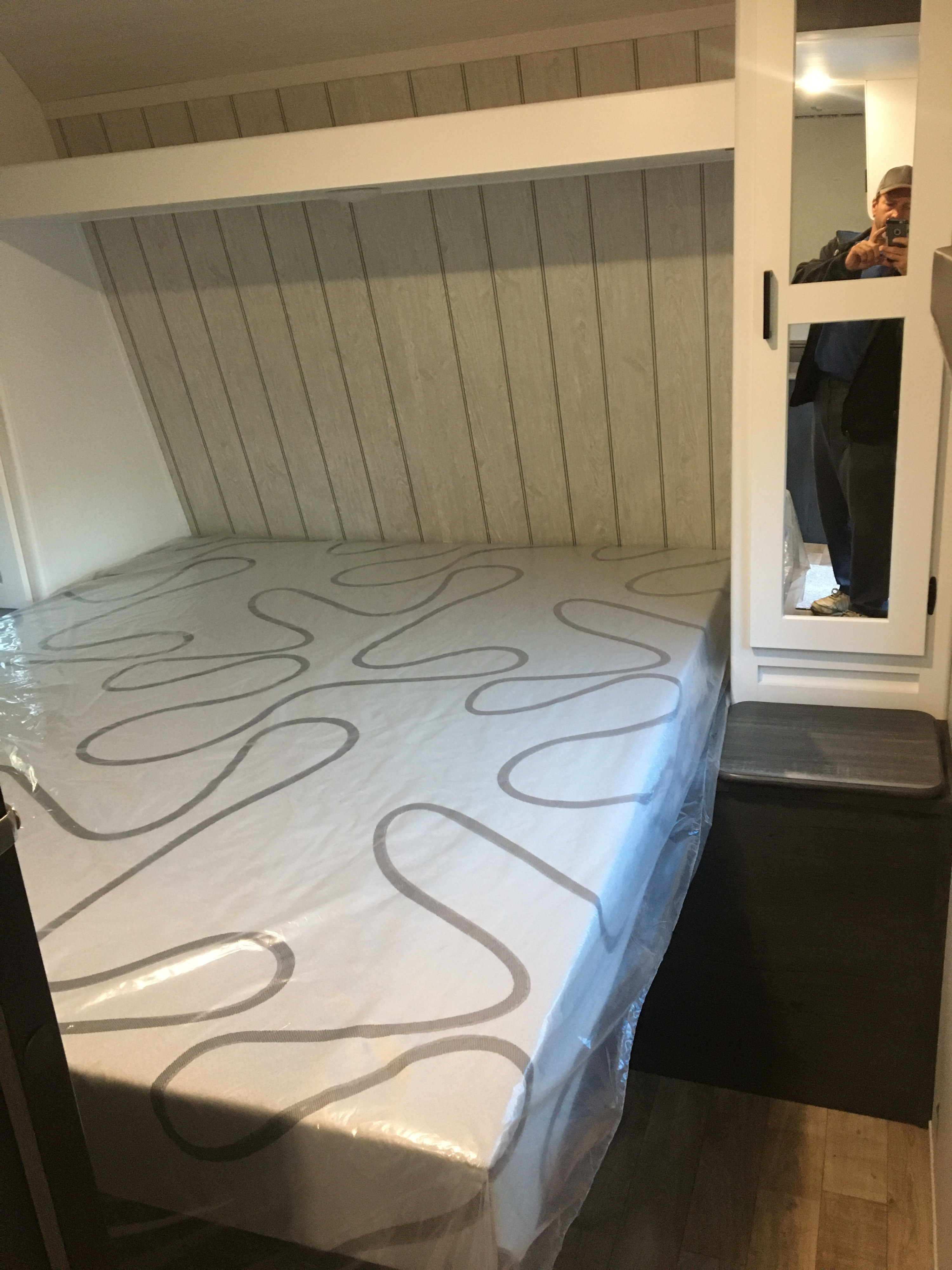 RV rental bedroom interior: new mattress in plastic, built-in bed nook, and mirrored closet. Ready for adventure!. Keystone RV Hideout 2023