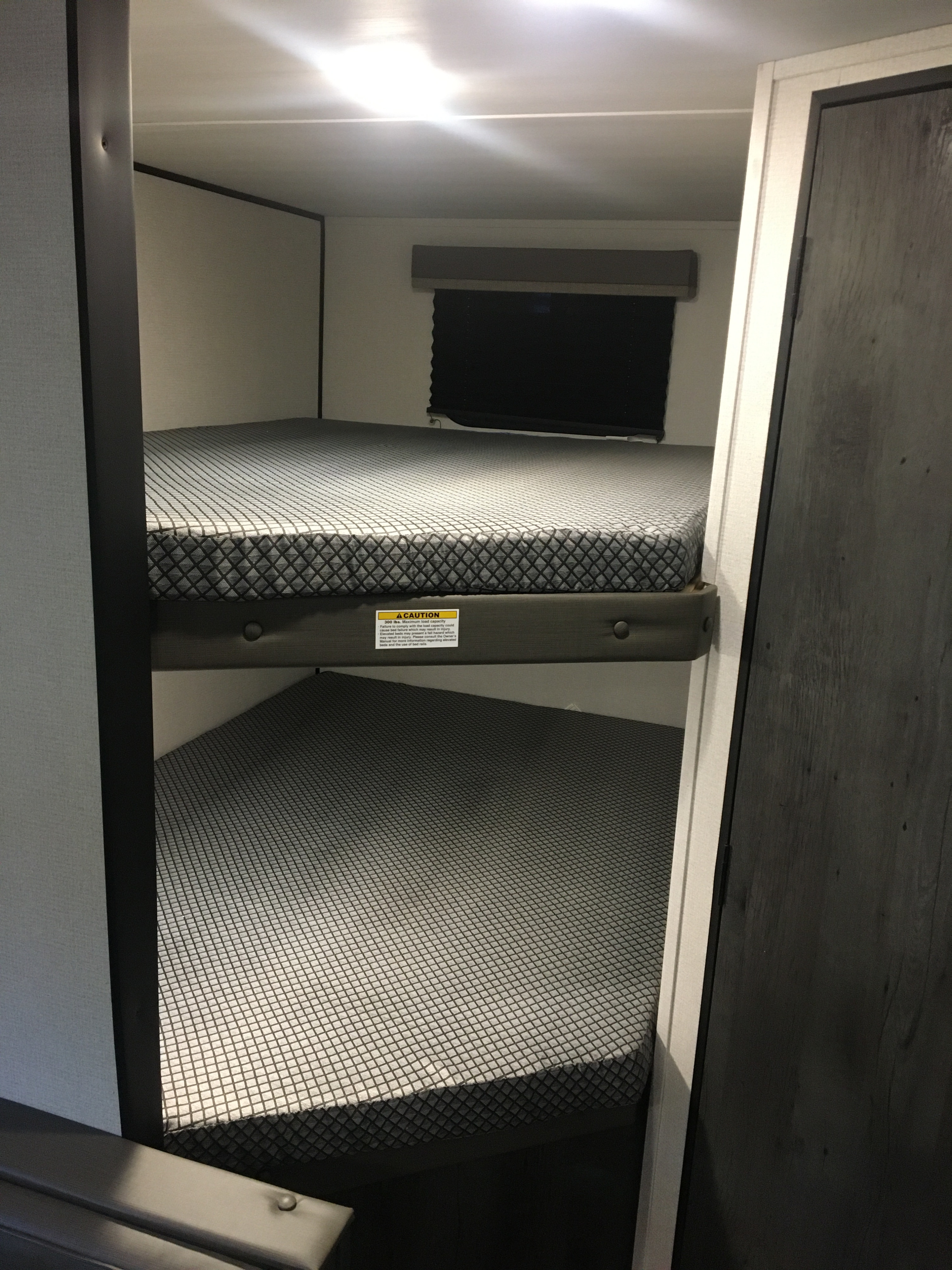 RV rental: Two stacked bunk beds with patterned mattresses inside a compact and functional interior for sleeping.. Keystone RV Hideout 2023