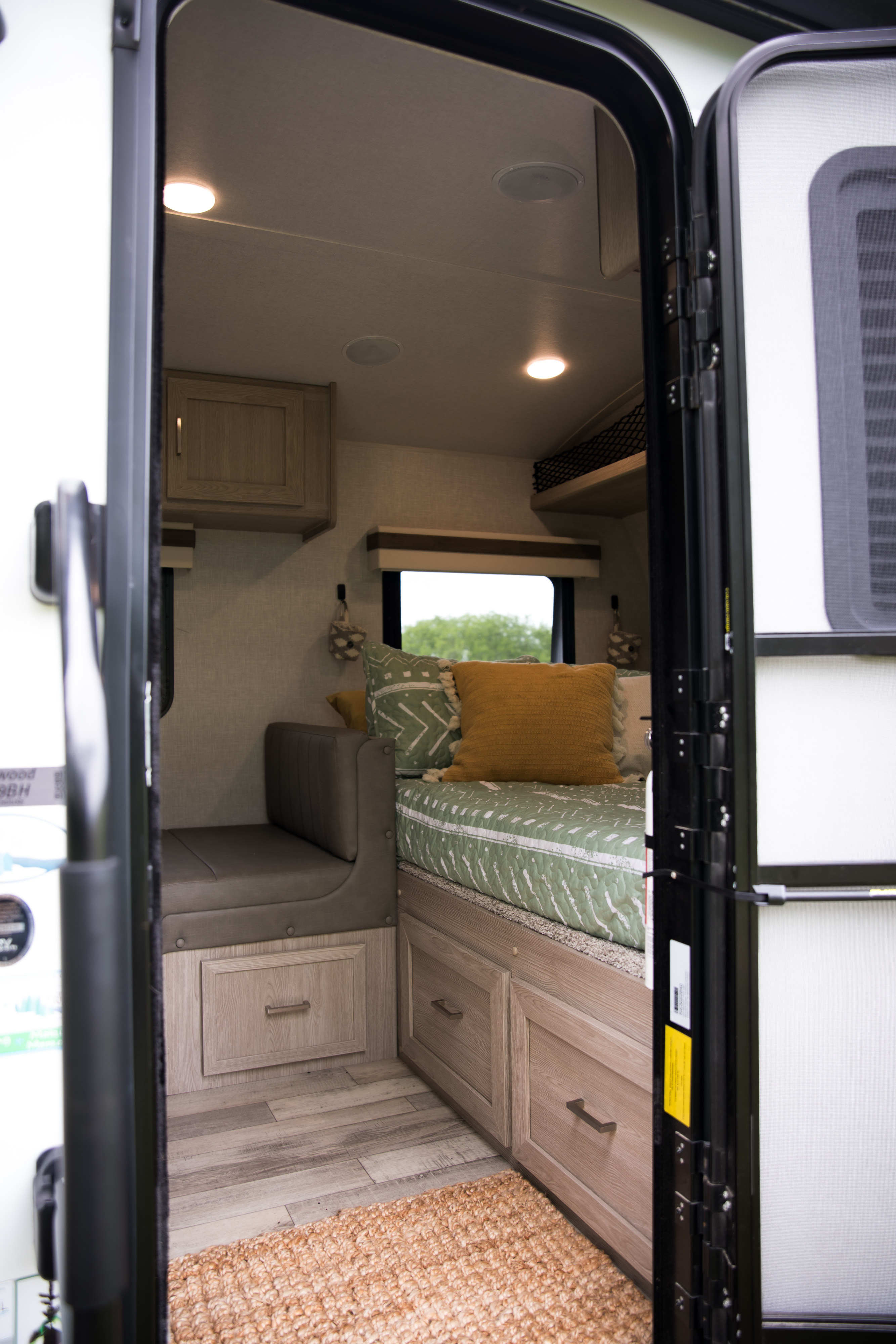 RV rental interior: Cozy living space with a bed, bench seating, and ample built-in storage, ideal for travel.. Forest River Rockwood Geo Pro 2022