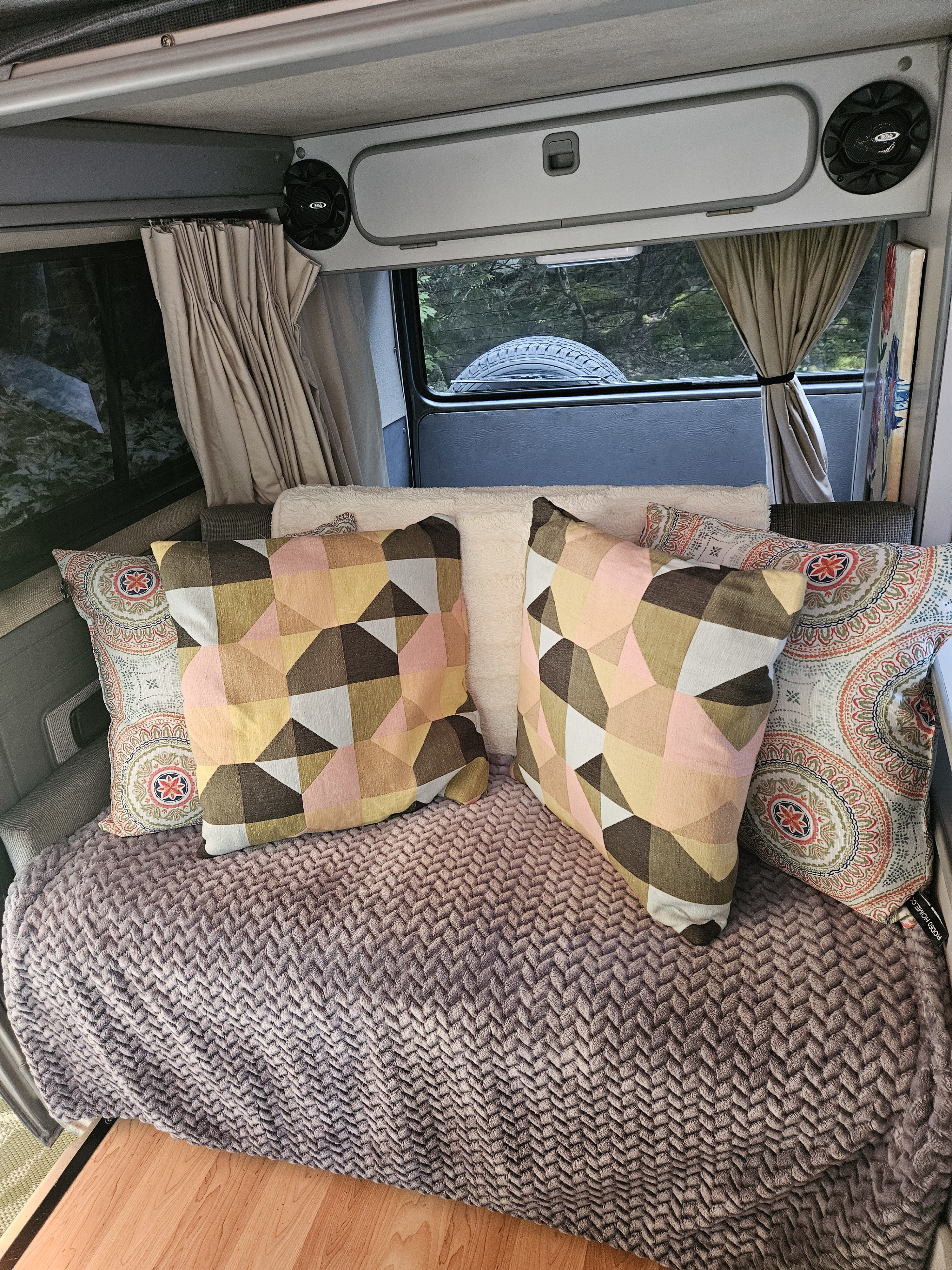 Relax in your cozy RV rental with stylish geometric and mandala pillows, soft blanket, and scenic nature views.. Westfalia T3 Westfalia 1987