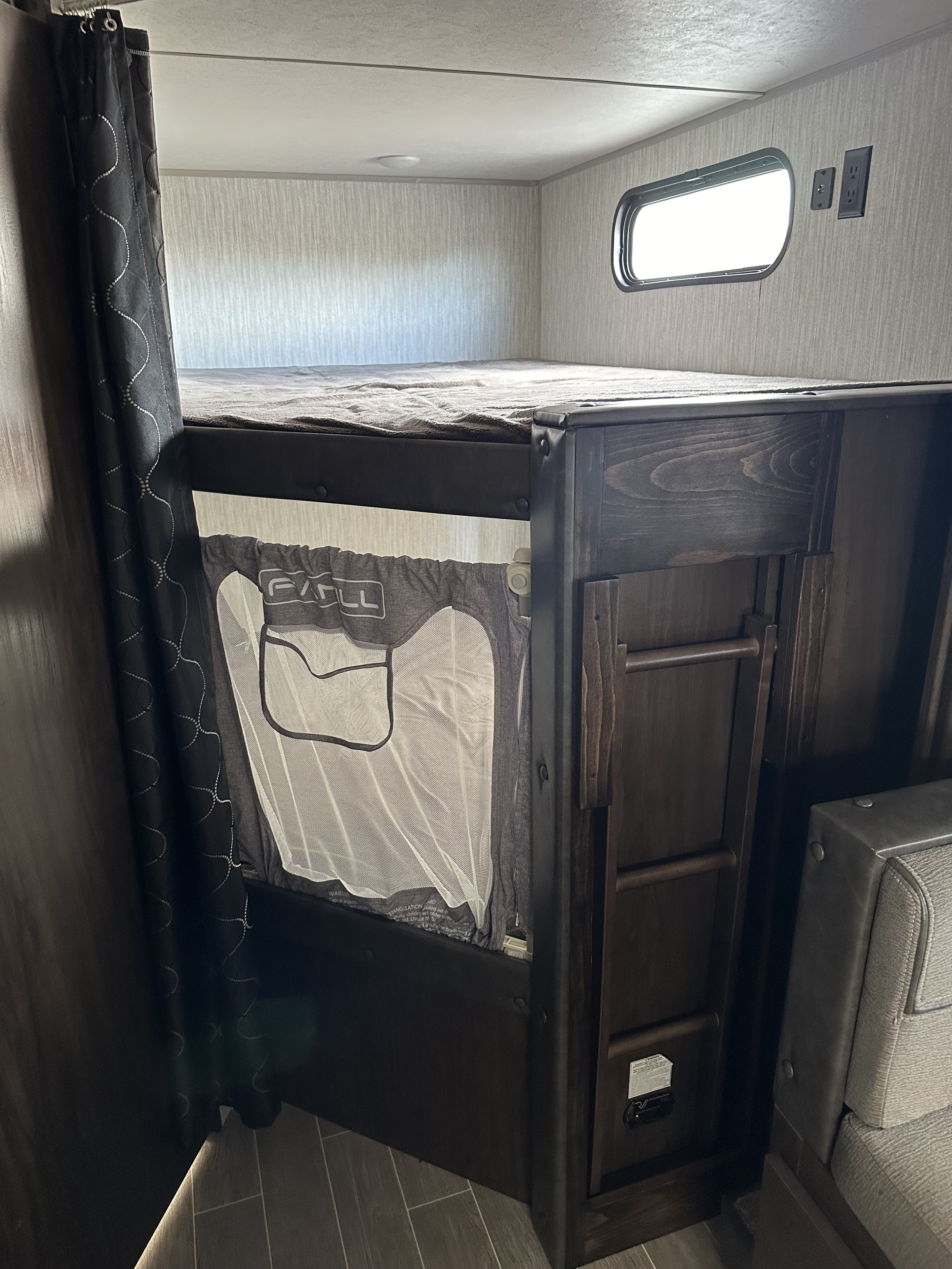 RV rental: Bunk bed with a child safety net attached to the lower bunk, providing a secure sleeping area for young ones.. Forest River Cherokee Grey Wolf 2021