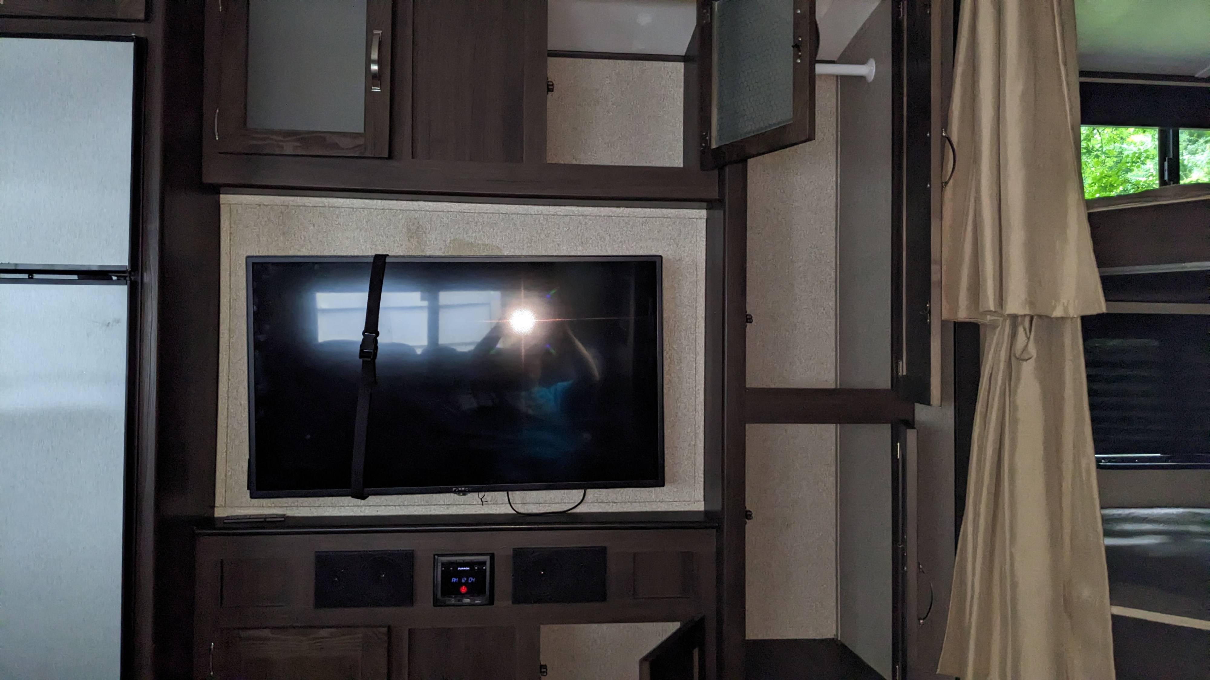 Spacious RV rental interior with an entertainment center, refrigerator, storage, and visible bunk beds, perfect for family trips.. Keystone RV Springdale 2019