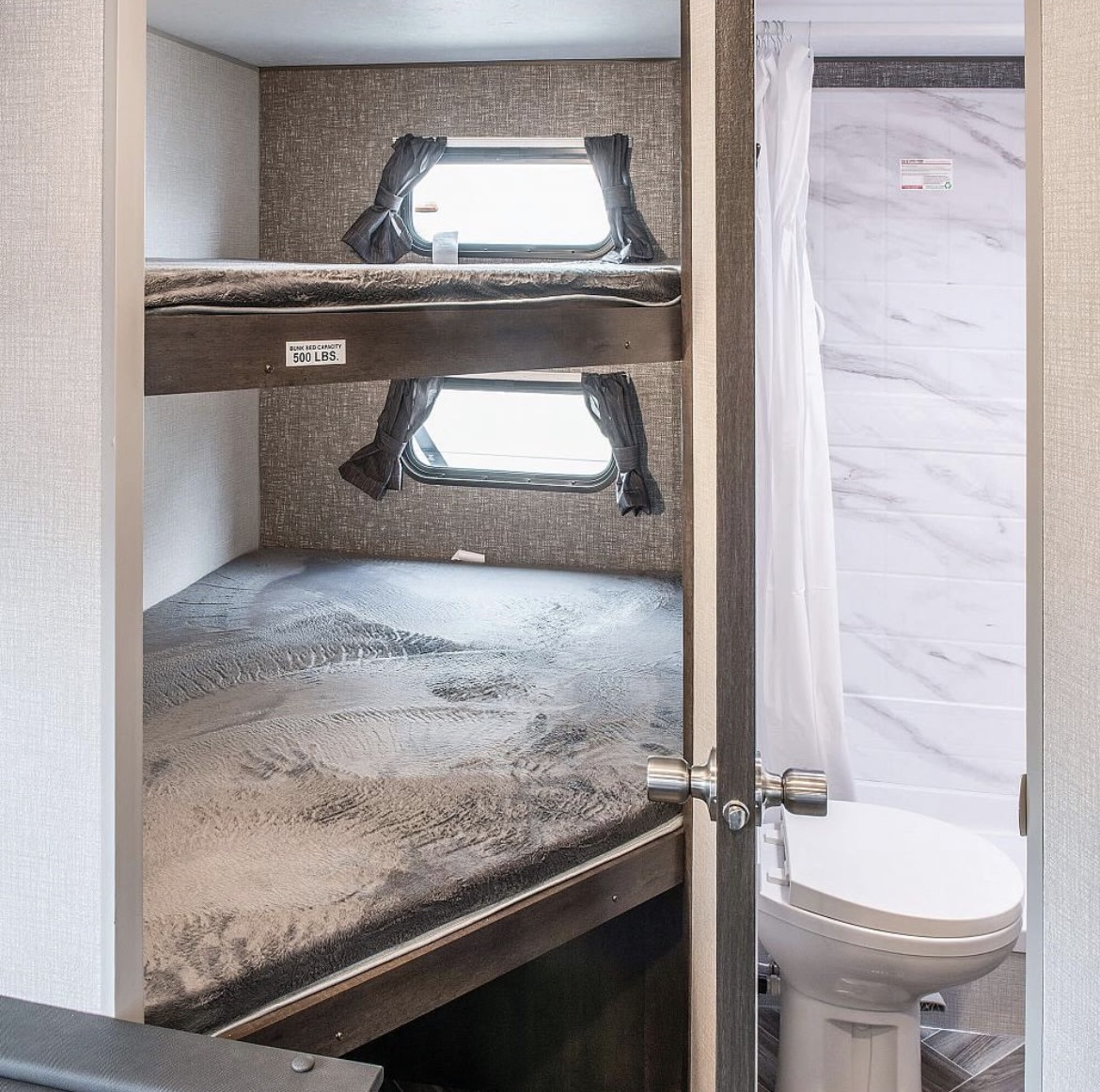 Spacious RV rental with cozy bunk beds (500 lbs capacity) and an adjacent modern bathroom with toilet.. KZ Sportsmen SE 260BHSE 2020