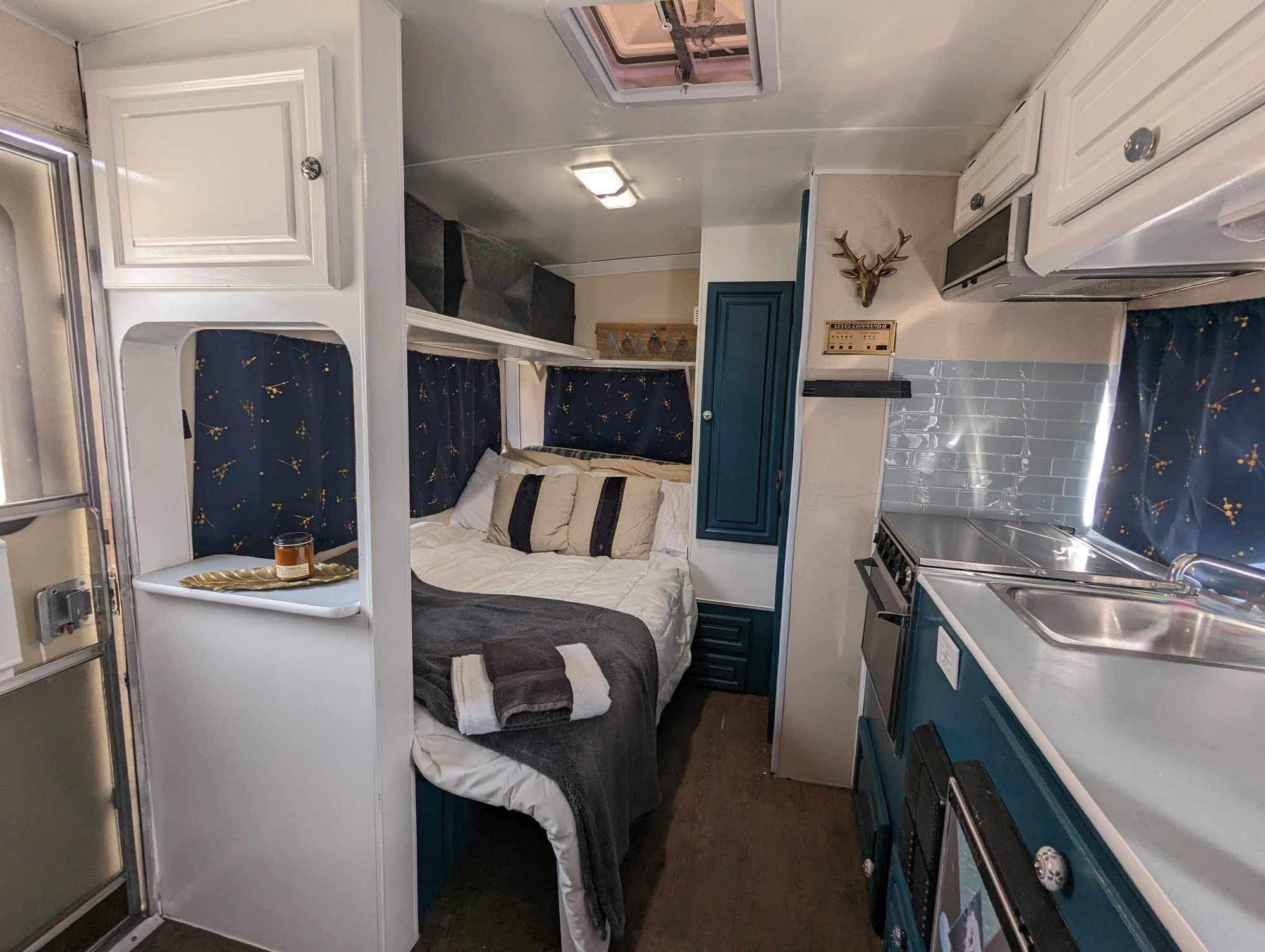 Cozy RV rental interior showcasing a bed area, compact kitchen, and inviting decor. Perfect for travel accommodations.. Bigfoot DXL 1987