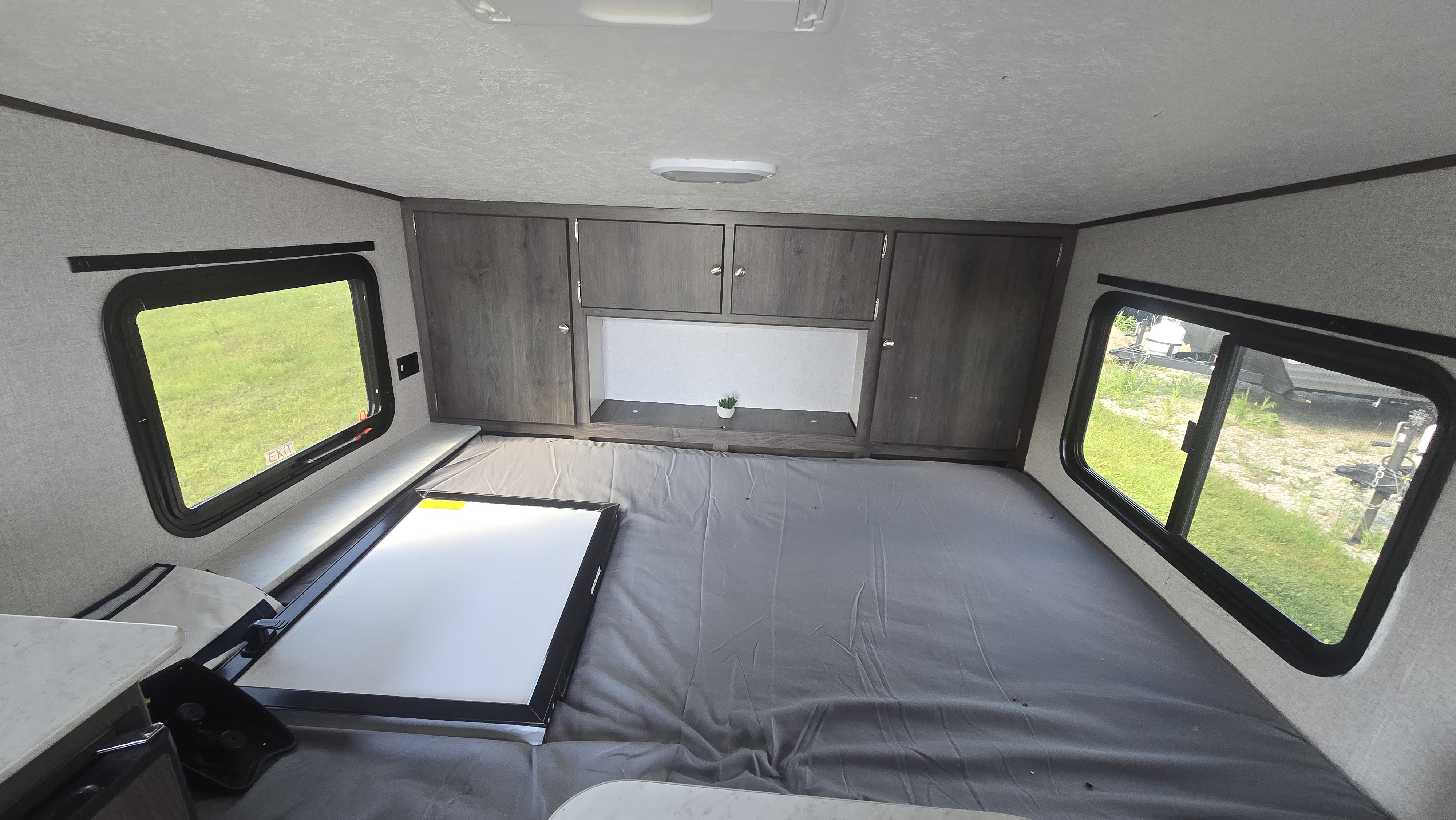 Compact RV rental interior featuring a large convertible bed, ample windows, and overhead storage. Ready for your adventure.. Coachmen Clipper 2020