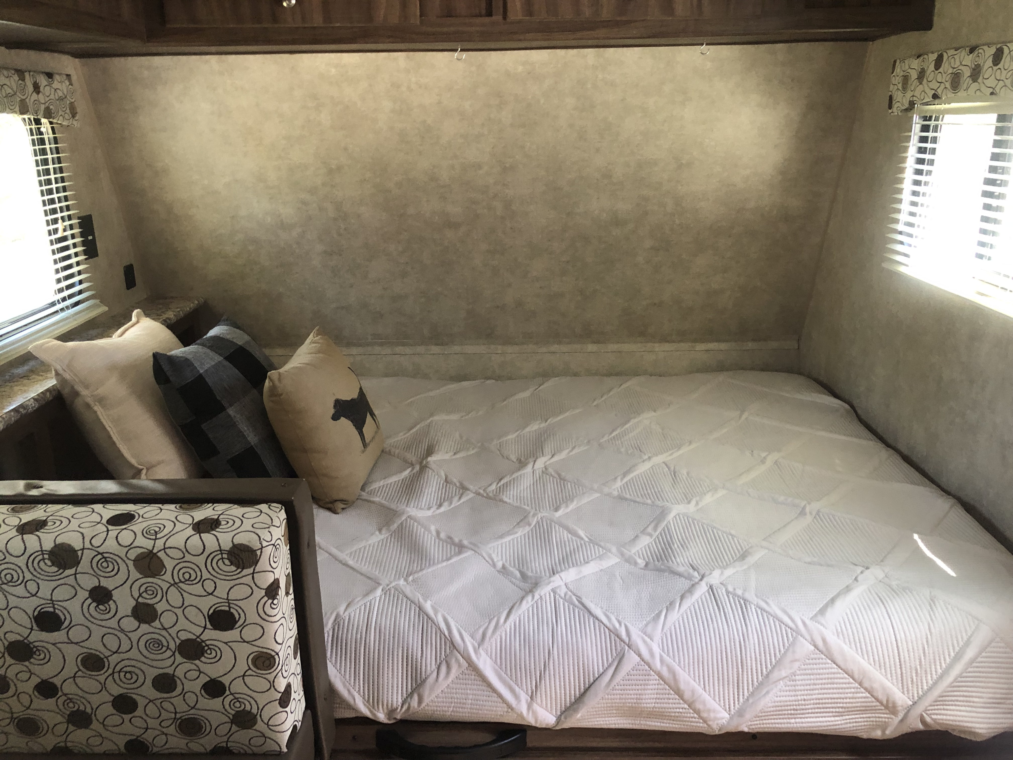 Comfy RV rental bedroom with a white quilted bed, cozy pillows, and windows, ideal for your next adventure.. Clipper Cadet 2018