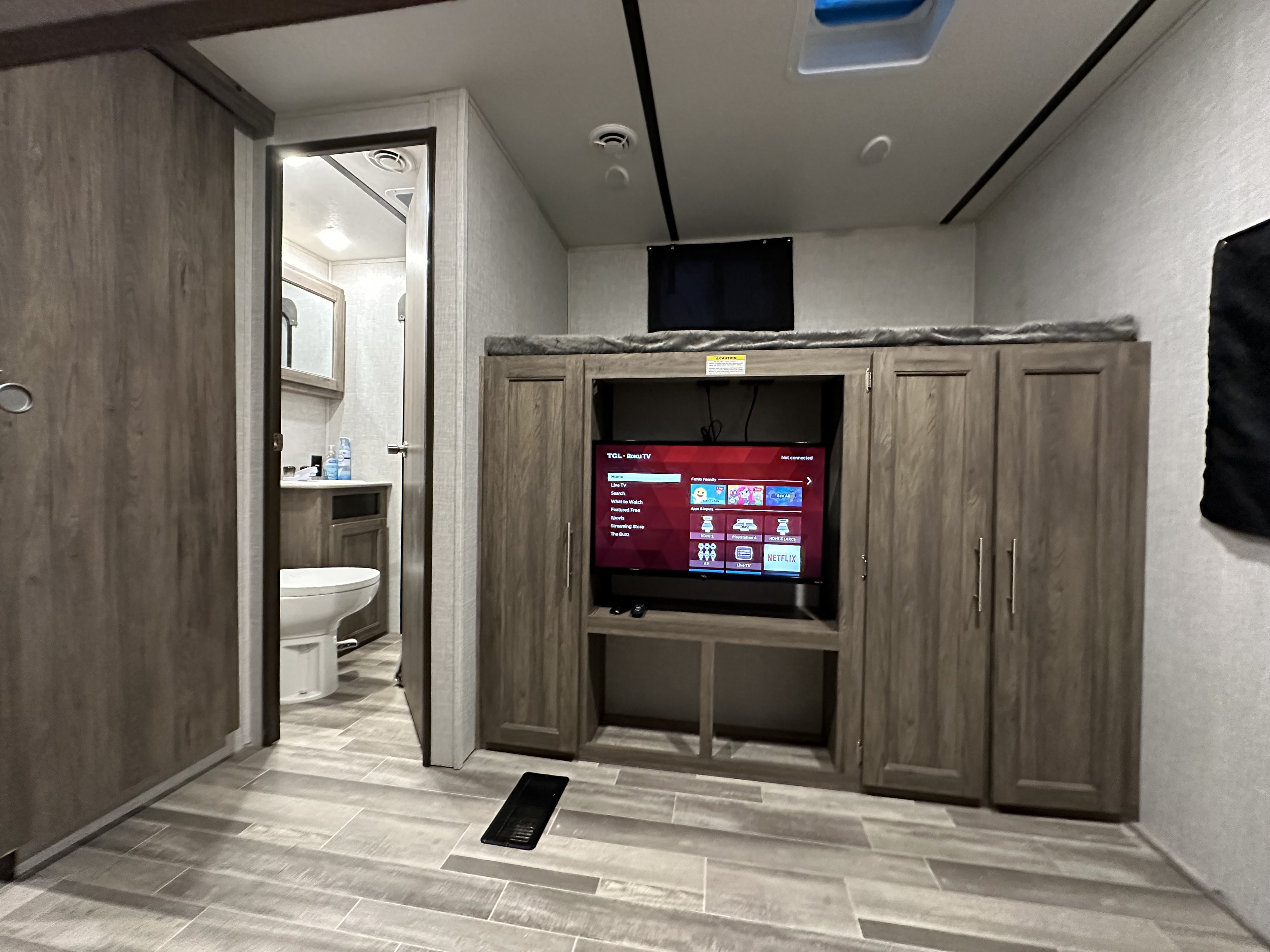 This RV rental's modern interior features a living area with TV and bunk bed, plus an accessible bathroom, ideal for family trips.. Crossroads RV Zinger 2021
