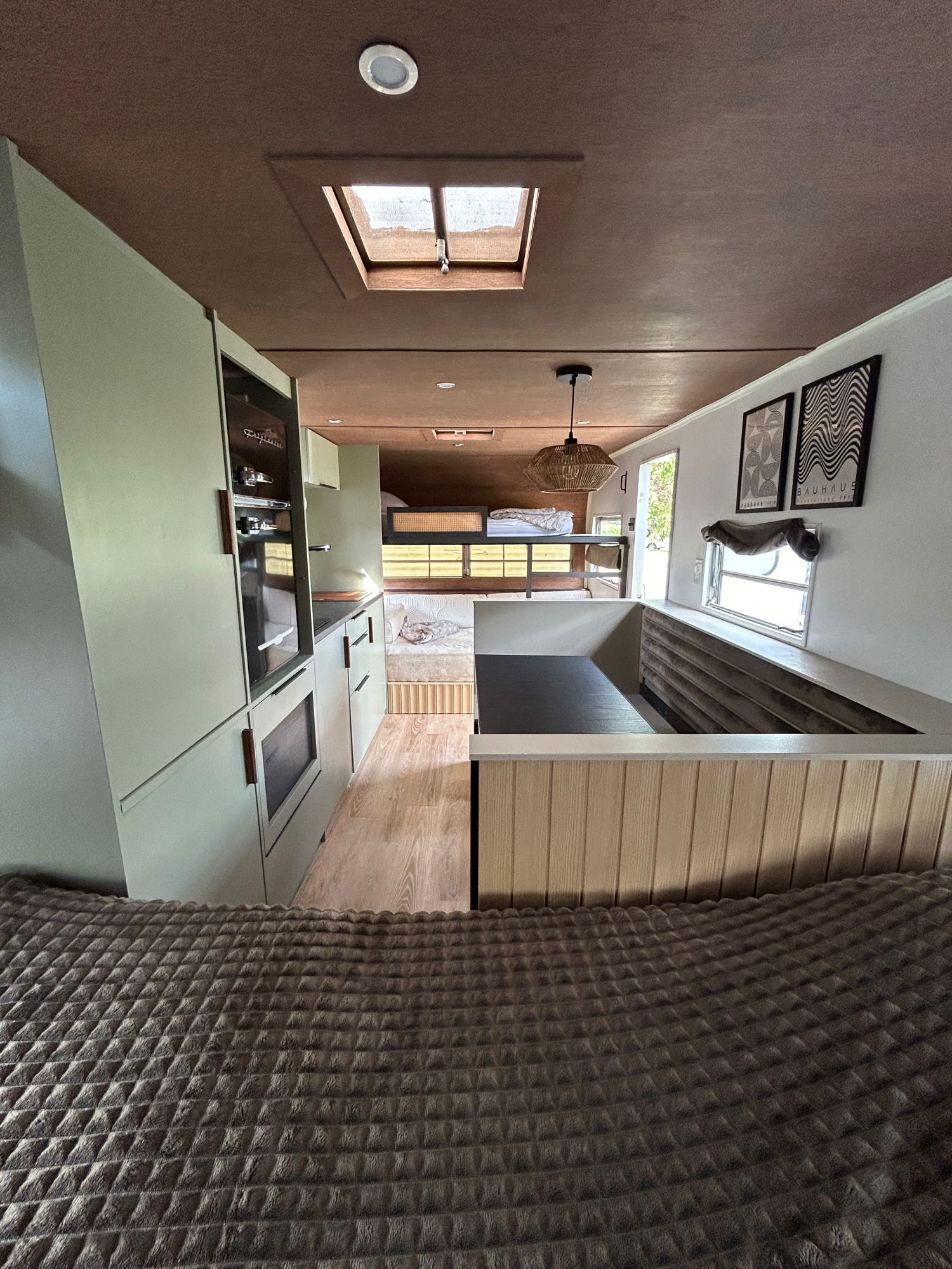 This modern rv rental interior features a functional kitchen, beds, skylight, and inviting living space.. Glendale Golden Falcon 1967