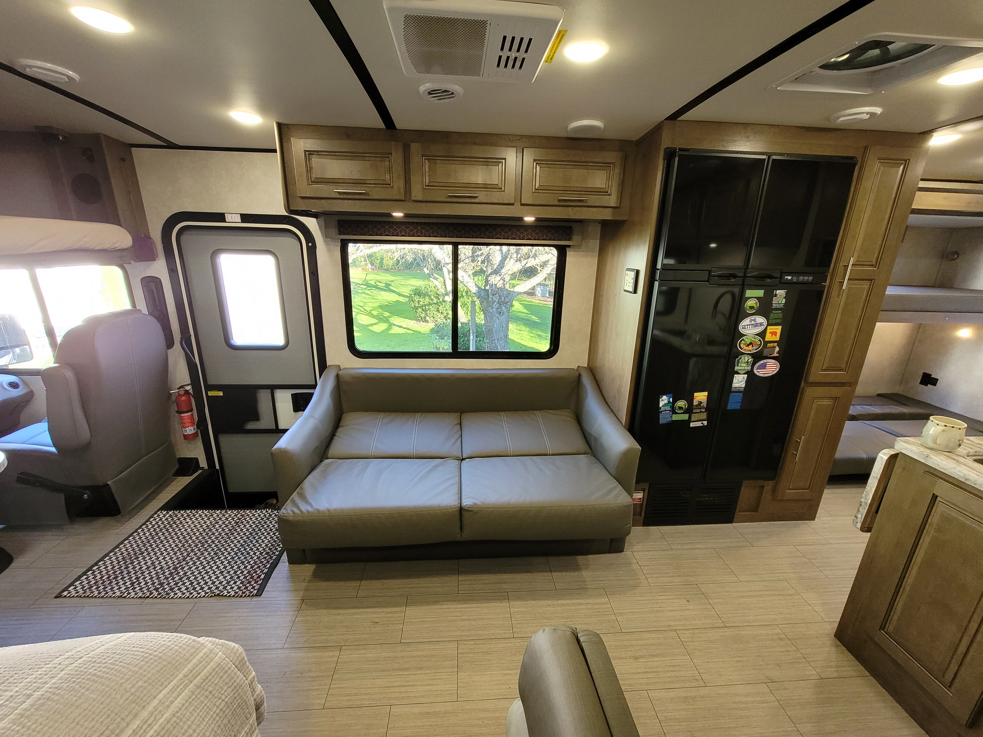 Comfortable RV rental interior with a flat sofa-bed, kitchen, bunk beds, and scenic views, perfect for trips.. Forest River FR3 2020