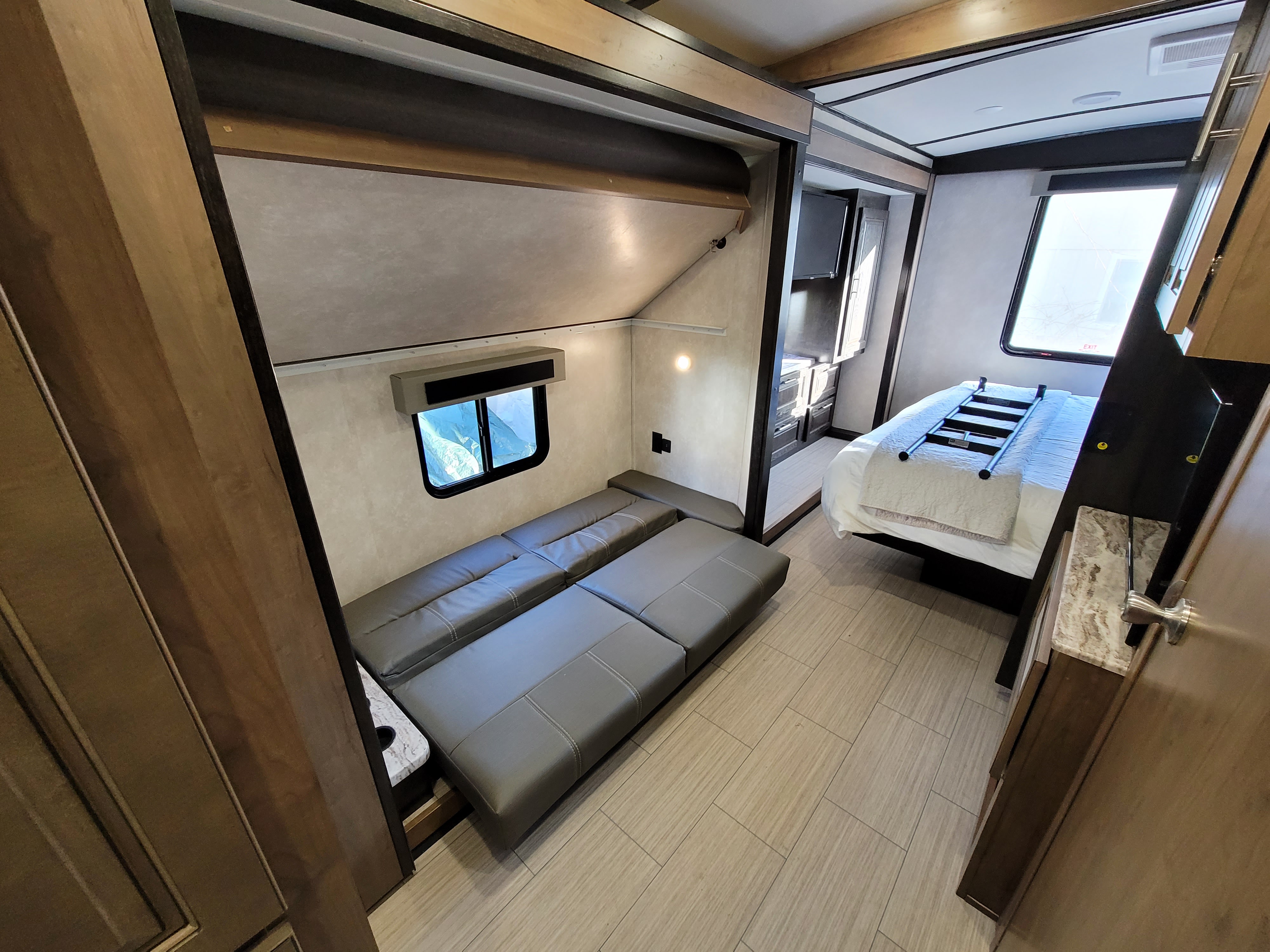 RV rental interior: bedroom with master bed and separate bunk area featuring a convertible sofa. Ready for your trip!. Forest River FR3 2020