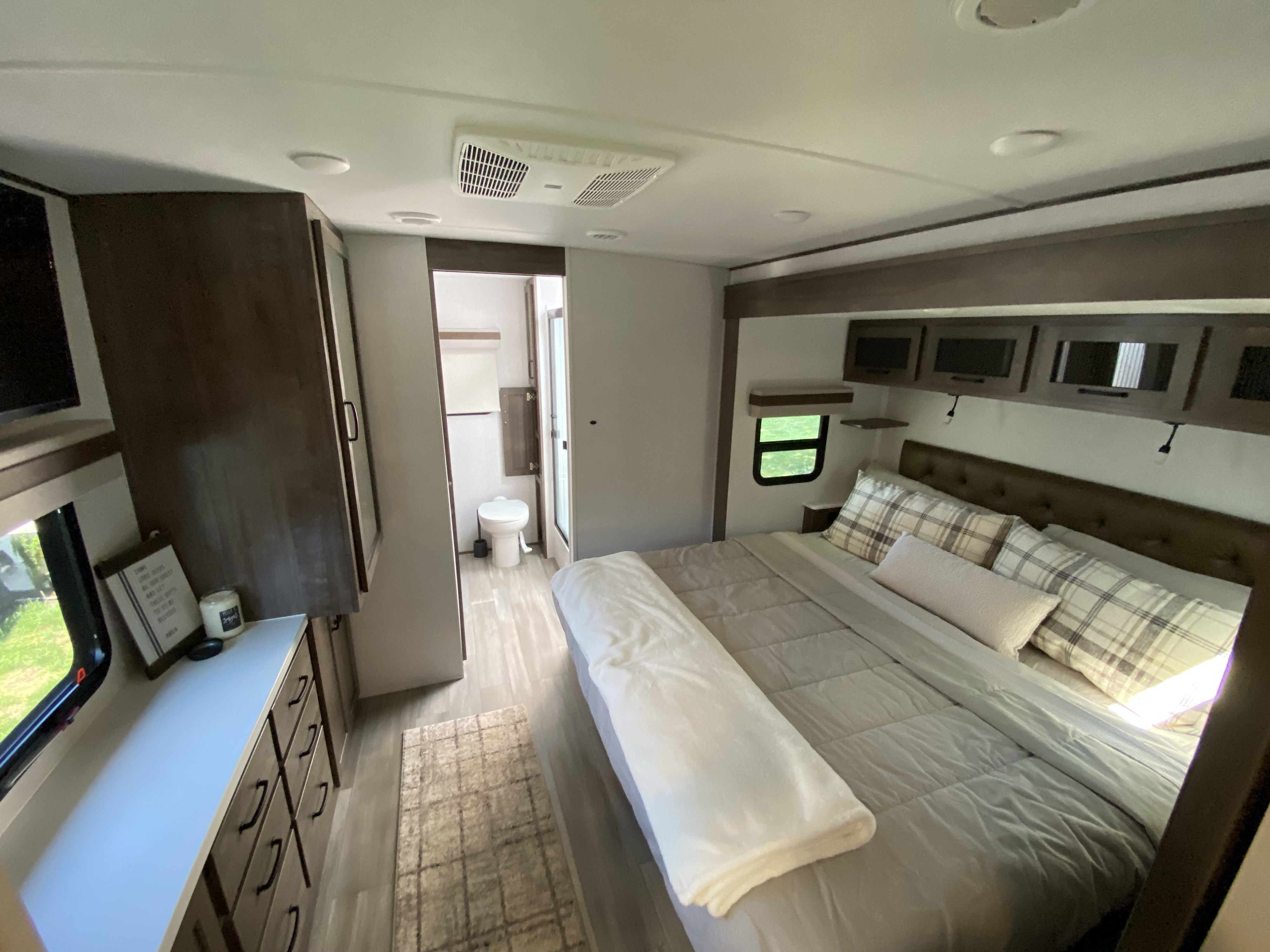 Cozy, modern RV rental bedroom with a comfortable bed, ample storage, and private bathroom. Ready for adventure!. Forest River Rockwood Signature 2024