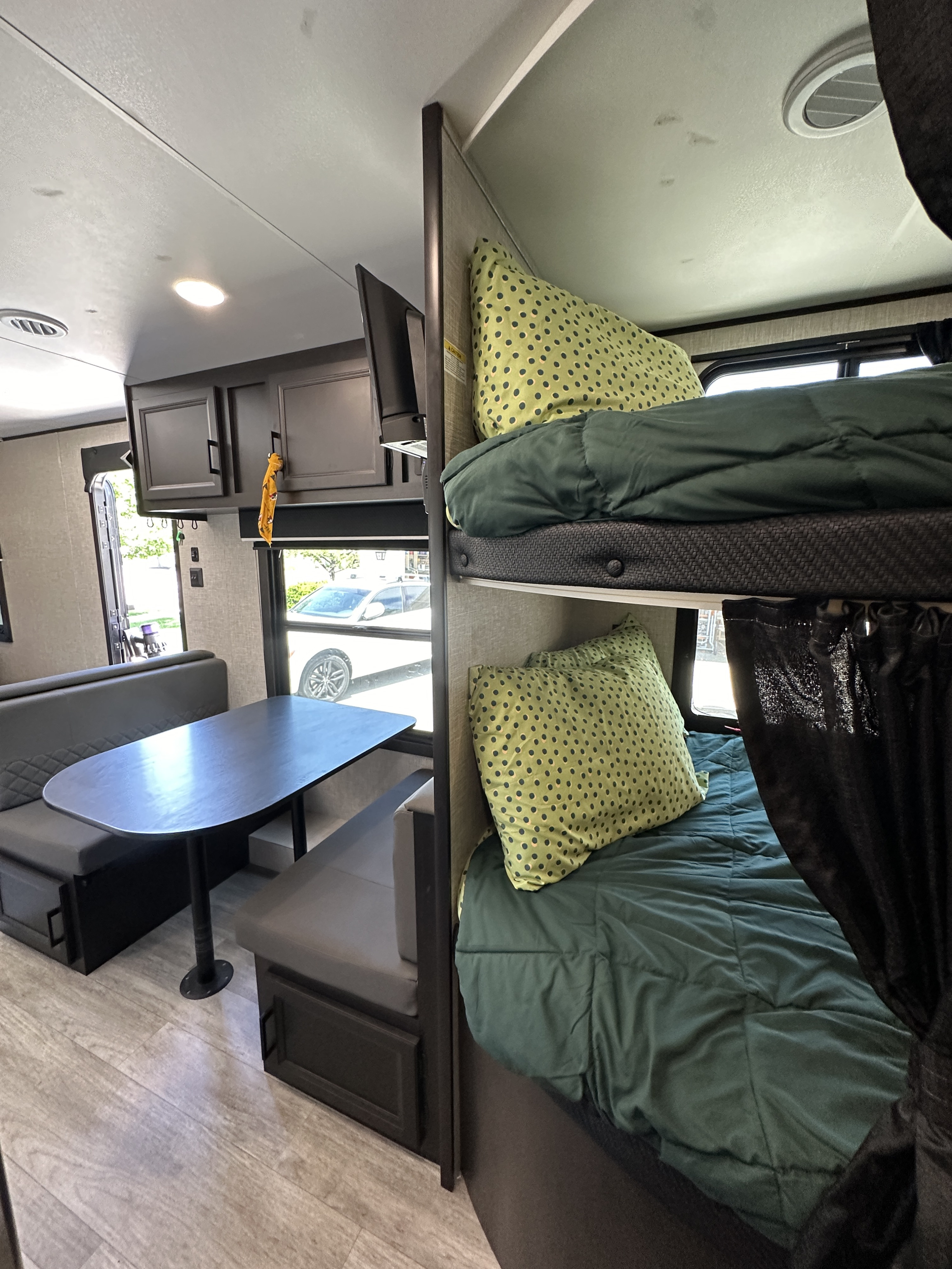 Inside this RV rental, find a cozy dinette, modern cabinets, and comfortable bunk beds for travel.. Jayco Jay Flight SLX Baja Edition 2023