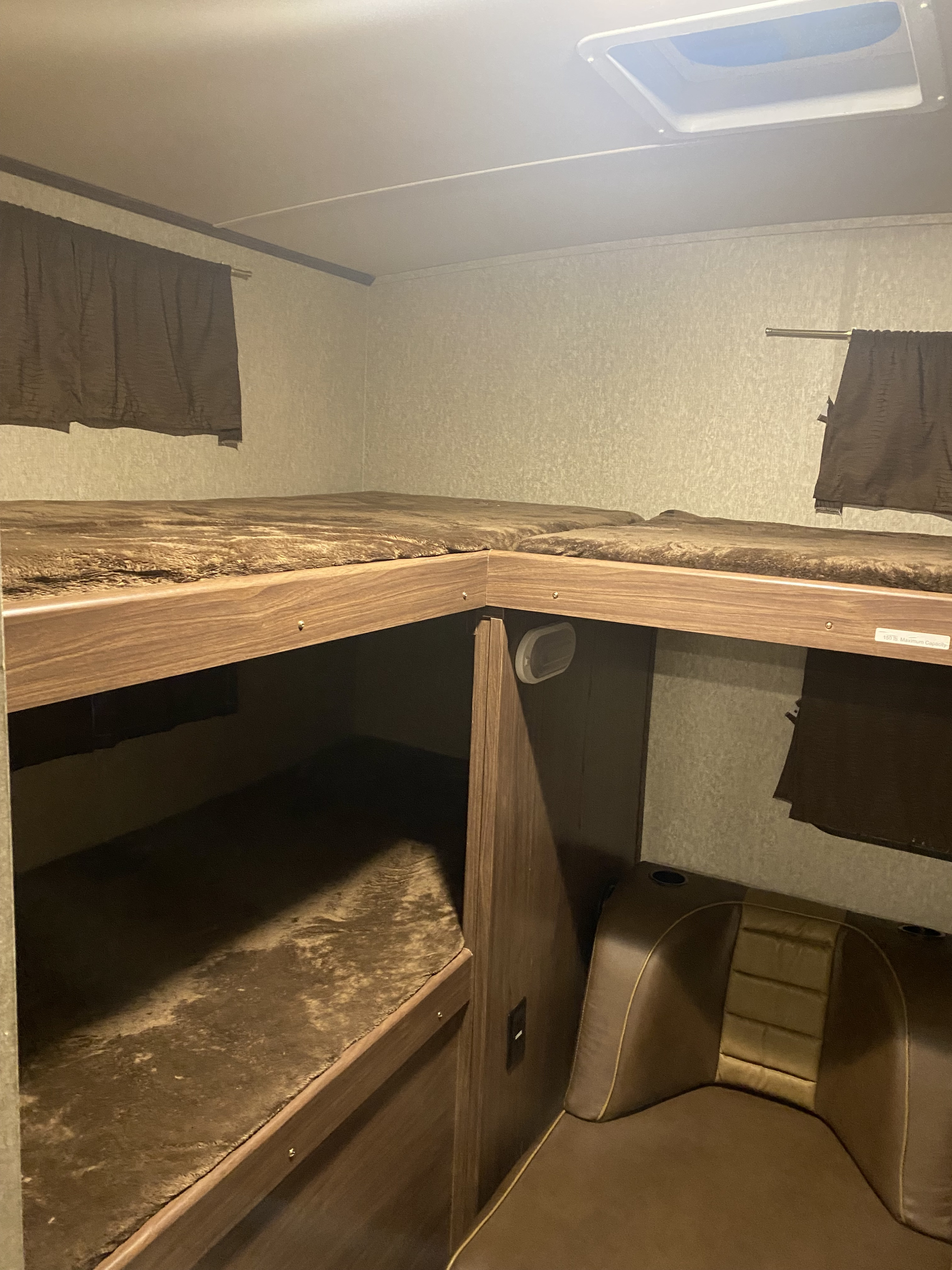 RV rental: Inside, brown bunk beds, a skylight, and a comfy brown couch with cupholders.. Palomino Solaire 2015