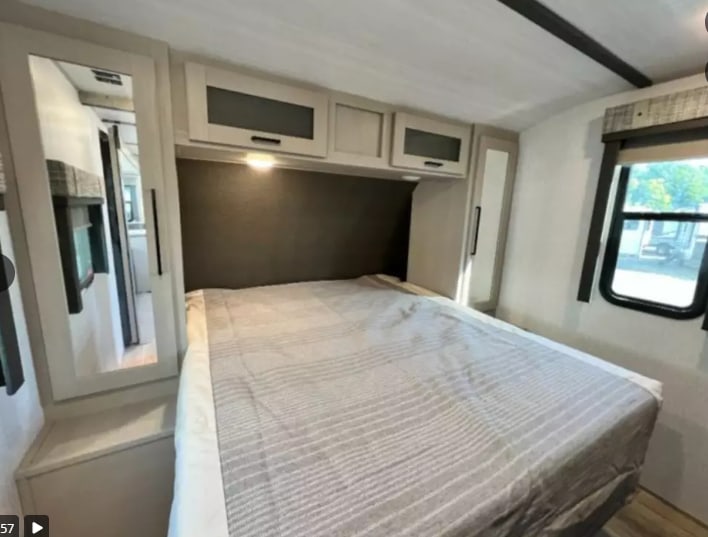 Experience comfort in this RV rental bedroom featuring a cozy bed, overhead storage, and mirrored wardrobe.. Forest River Salem Hemisphere HL 2022