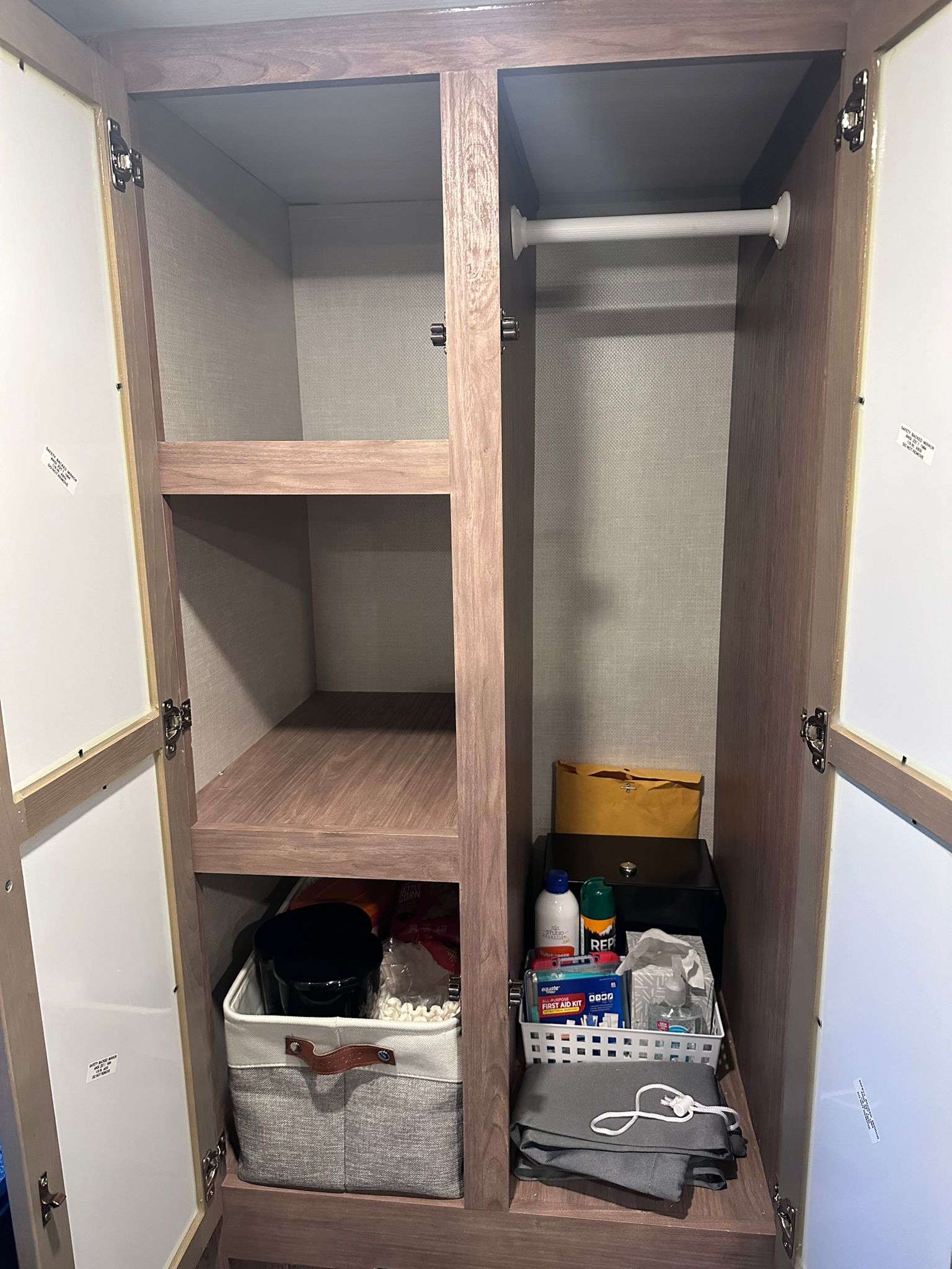 Organized RV rental closet: shelves, a hanging rod, and essential items like first aid, toiletries, and storage bins.. No Boundaries 19 2023