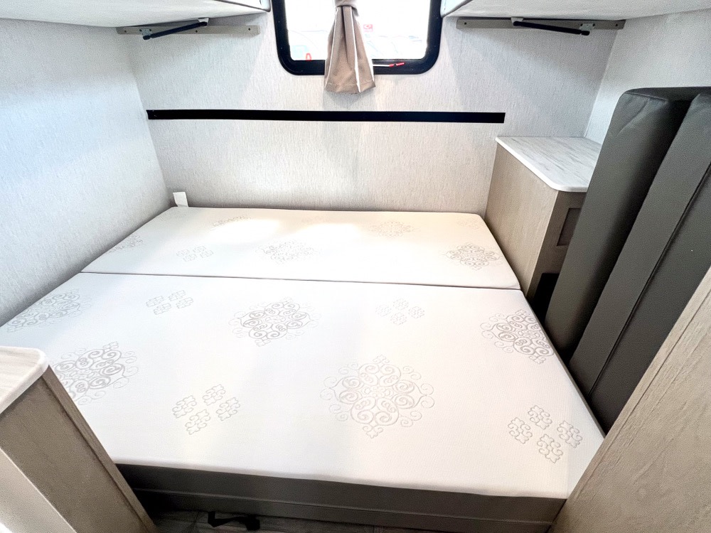 This RV rental features a cozy, compact sleeping area with a modular bed and stowed cushions, ideal for travel.. Forest River Salem Cruise Lite Platinum 2024