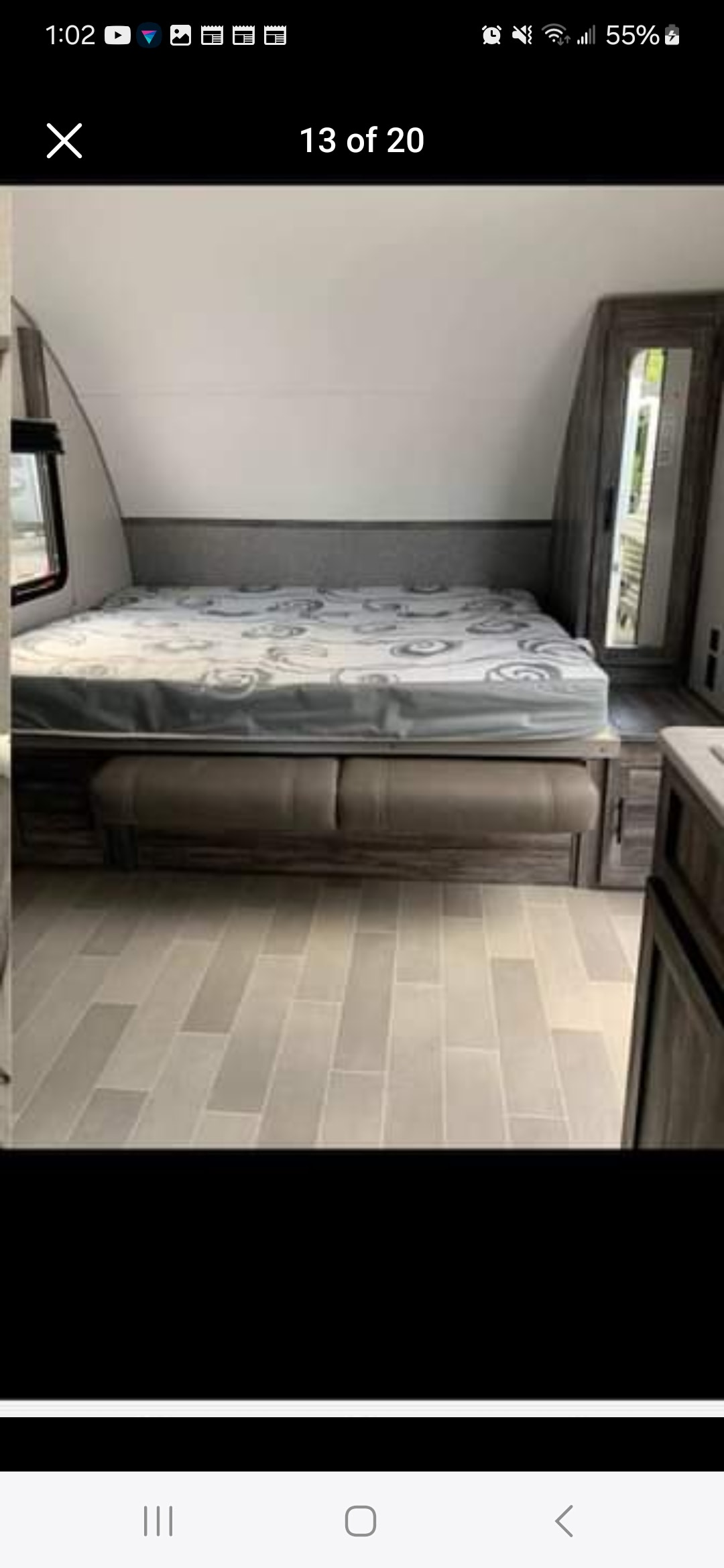 RV rental interior featuring a spacious bed, comfortable seating, and a mirrored wardrobe, all on light-tiled flooring.. Forest River Wildwood 2020