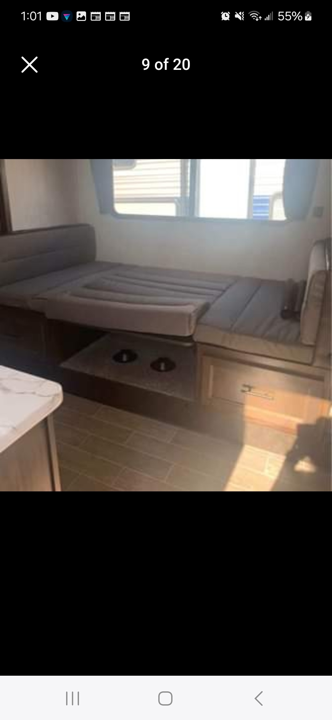 RV rental interior: A versatile grey cushioned dinette folds down to form a comfortable bed, with a small table base below.. Forest River Wildwood 2020