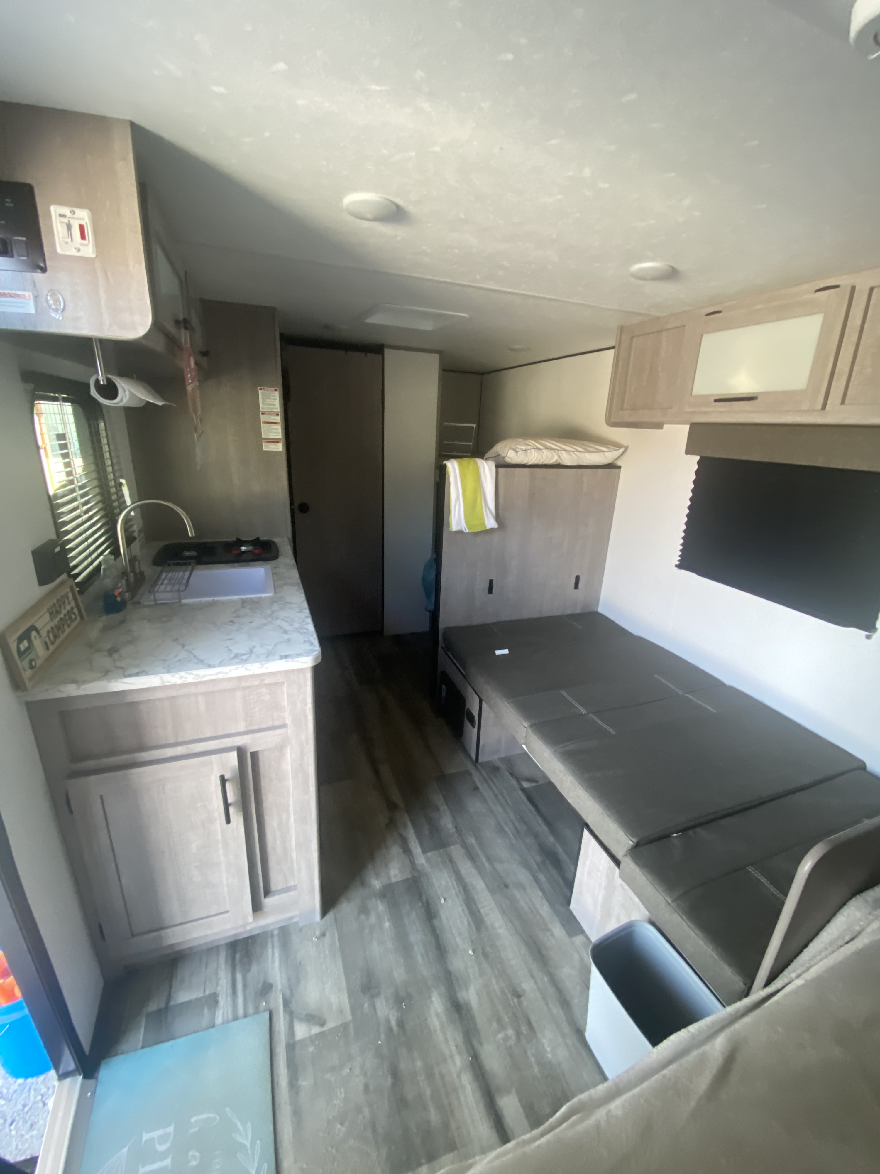 This RV rental interior features a compact kitchen on the left, with a convertible dinette bed on the right.. Coleman Lantern LT 17b 2024