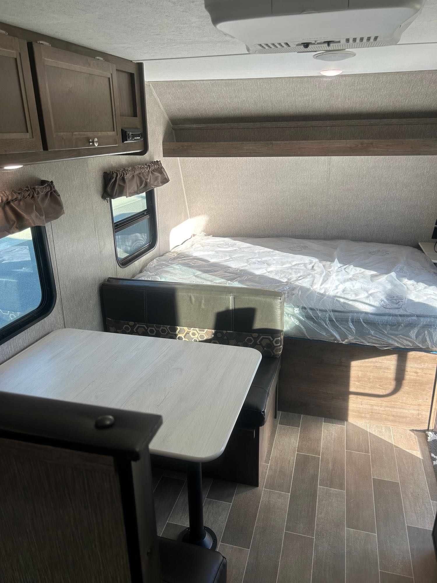This RV rental features a cozy dinette with booth seating and a bed with a mattress in plastic, ready for your adventure.. Coleman Lantern 17FQ 2020