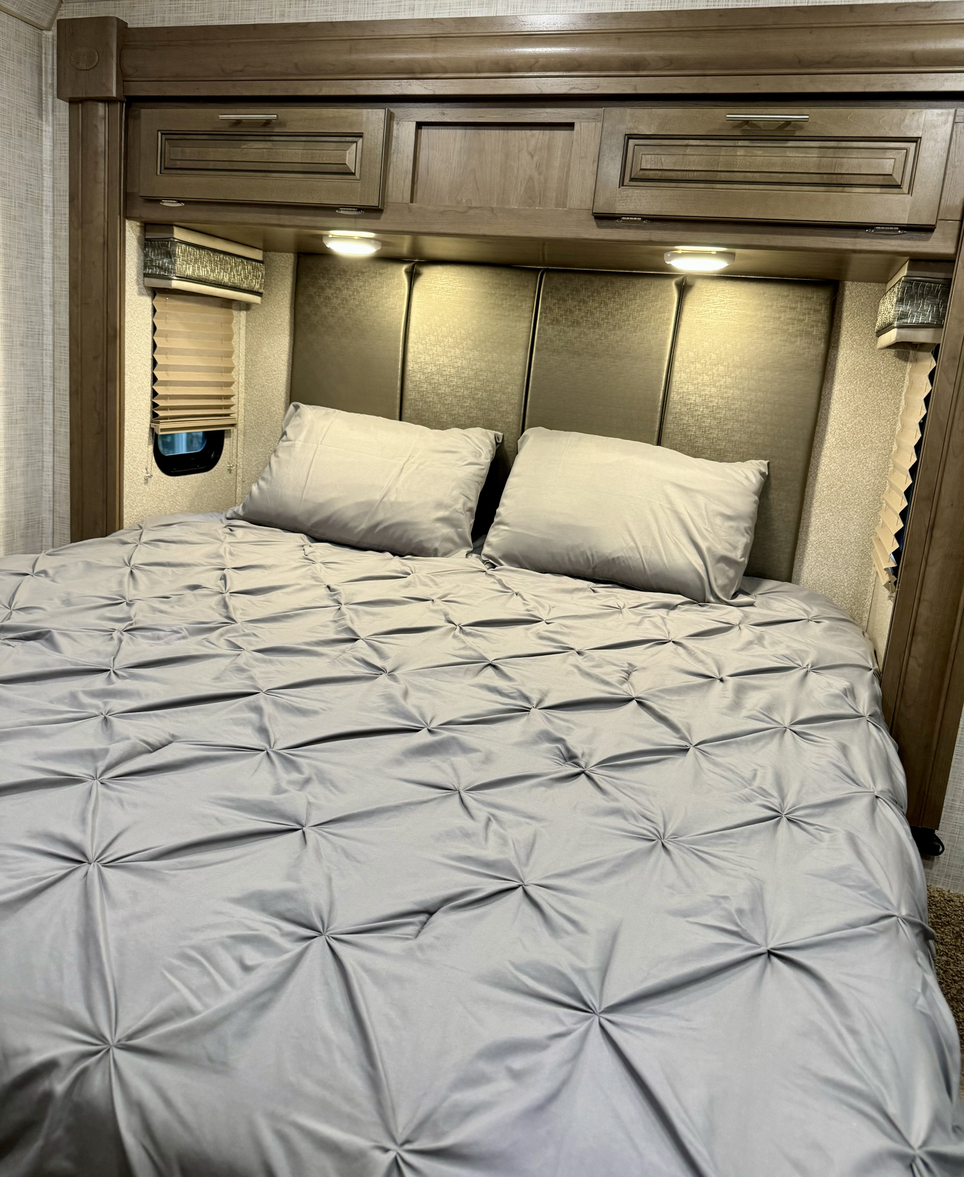 Comfortable RV rental bedroom featuring a plush bed, padded headboard, and convenient overhead storage for a restful trip.. Georgetown GT3 2019