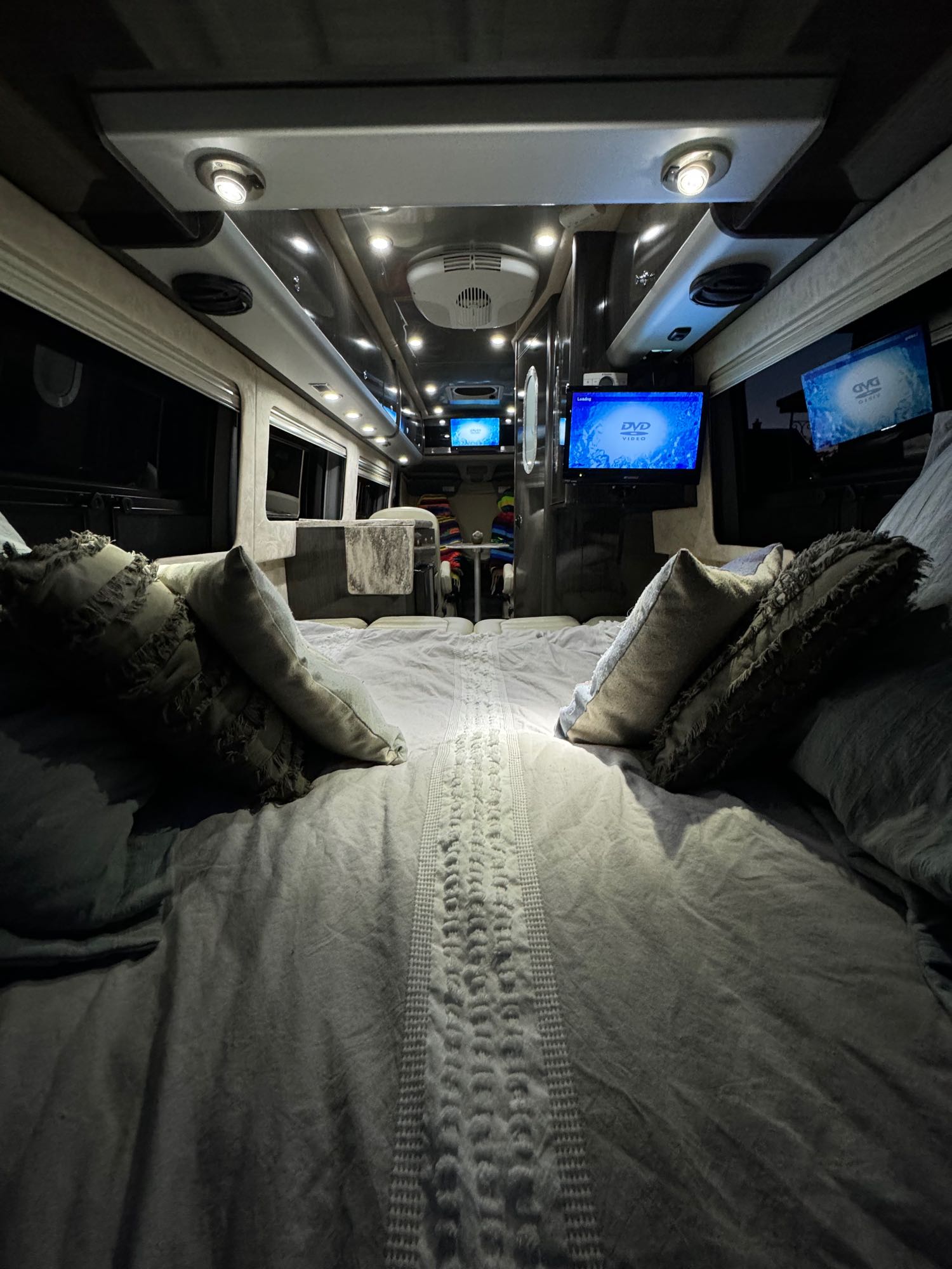Experience comfort in this luxurious RV rental interior. A cozy bed, multiple entertainment screens, and ambient lighting await your travels.. Airstream Interstate 2013