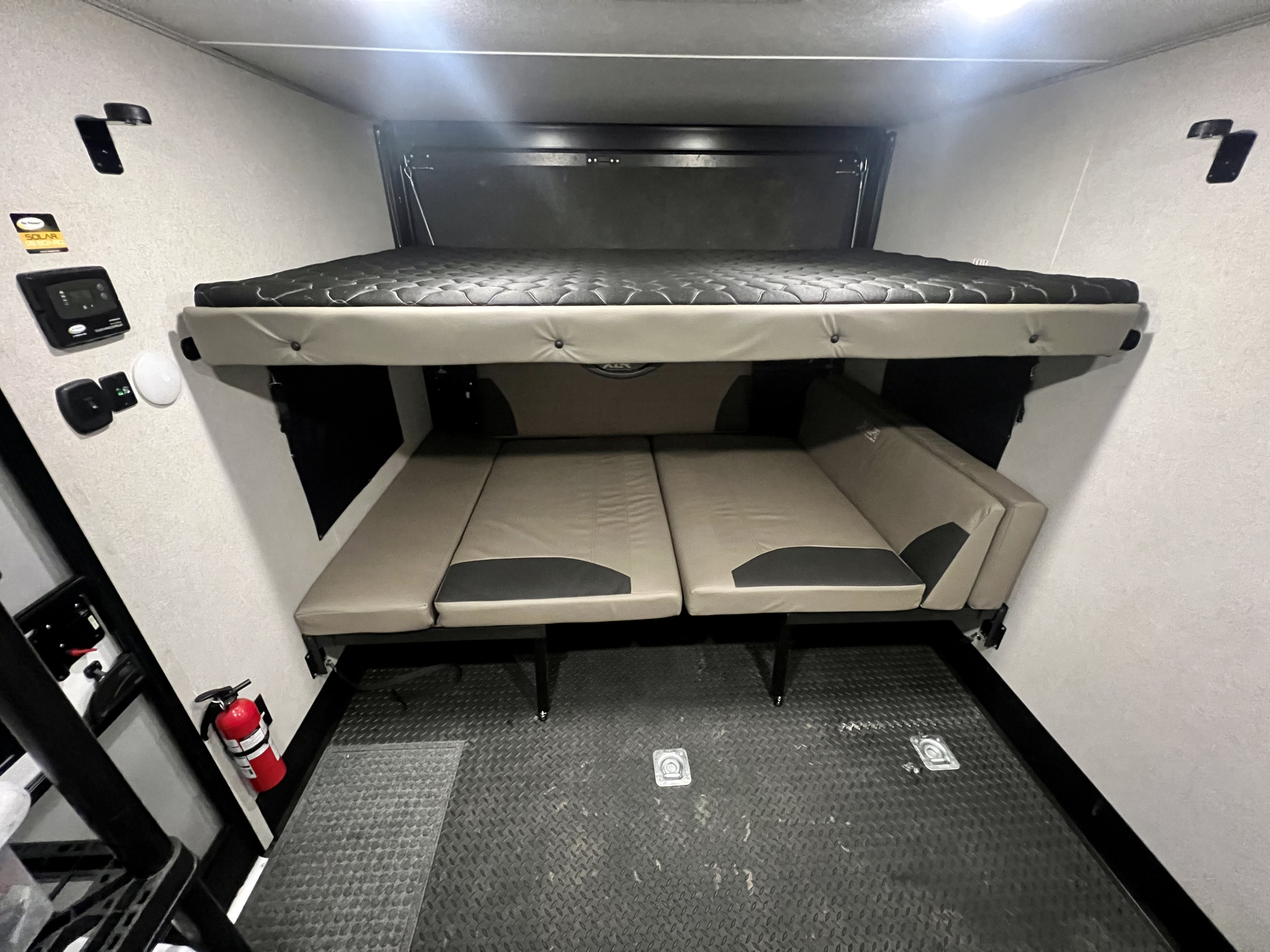 Spacious RV rental interior: upper bunk bed, lower convertible sofa/beds, diamond plate floor, and solar controls.. Forest River Xlr Thunrderbolt 2022