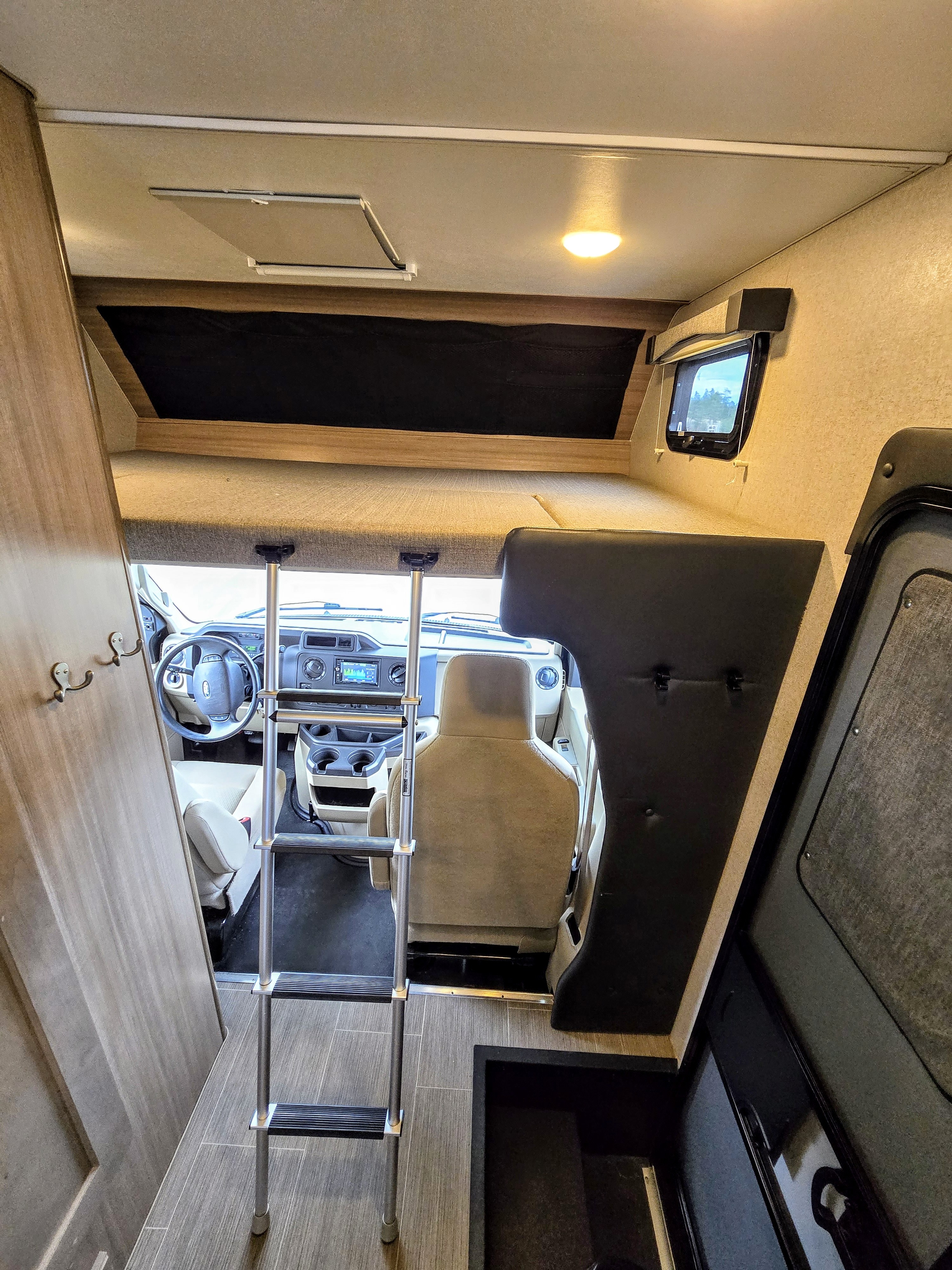 RV rental interior: Cab-over bunk, ladder, and cockpit view.. ALP Adventurer 19RD 2021