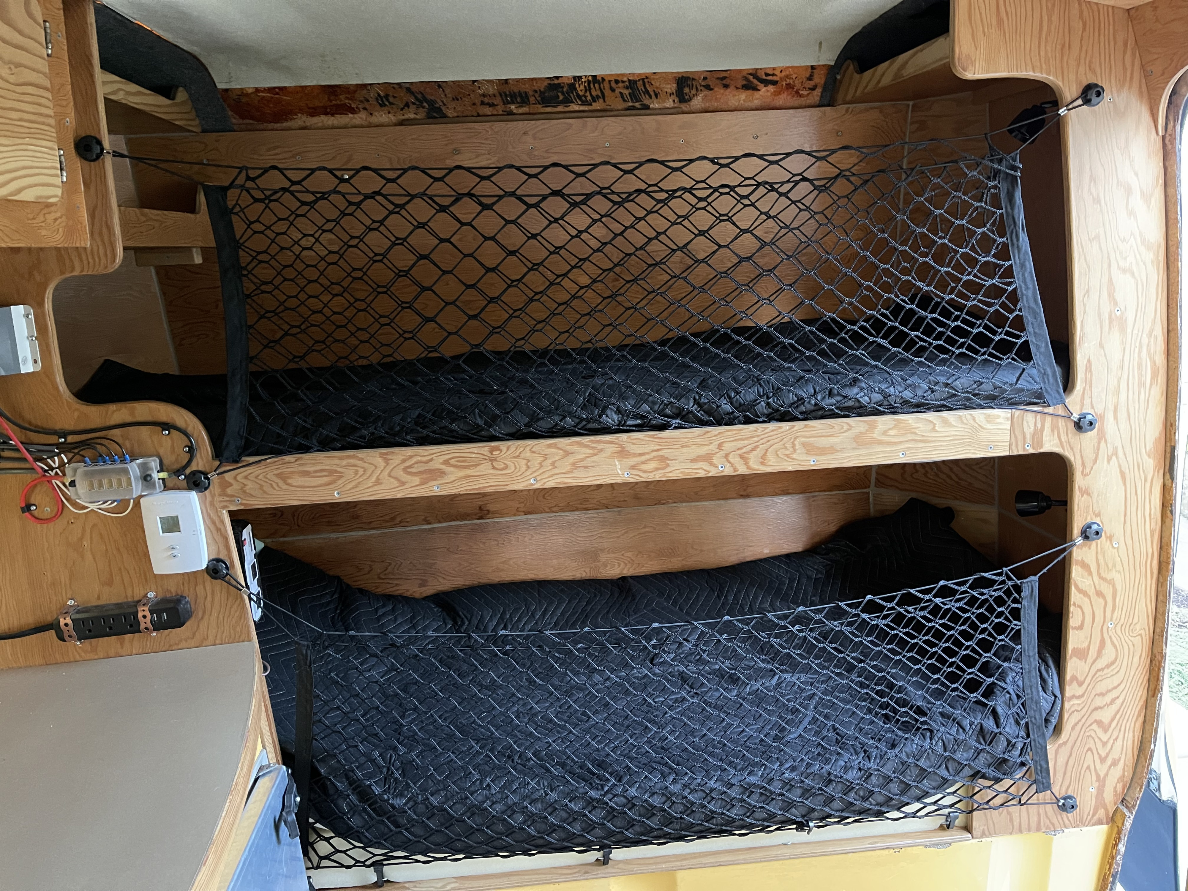 RV rental: Cozy interior features two bunks with storage nets, electrical wiring, and thermostat.. Trillium Rv 1300 1973