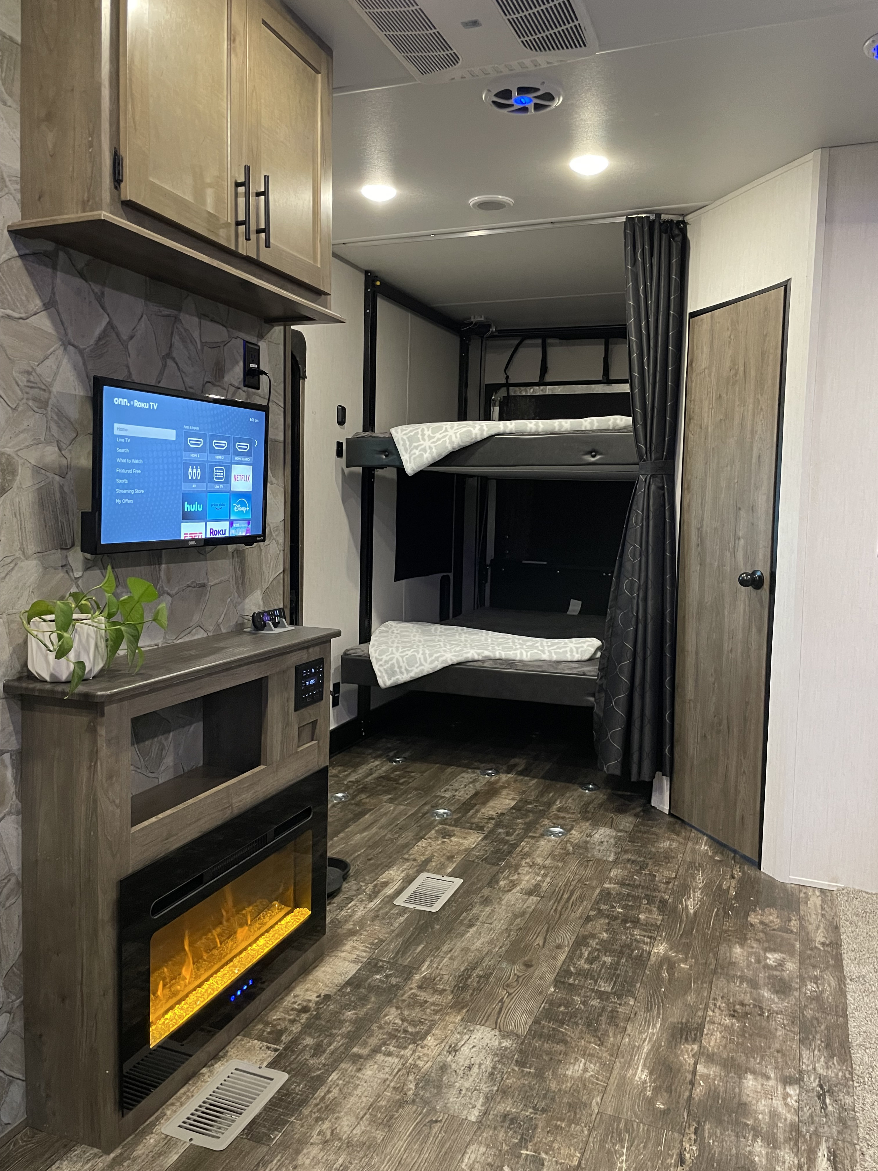 This cozy RV rental interior features a TV with streaming, a fireplace, and bunk beds for comfortable travel.. Forest River Cherokee Wolf Pack Toy Hauler 2021