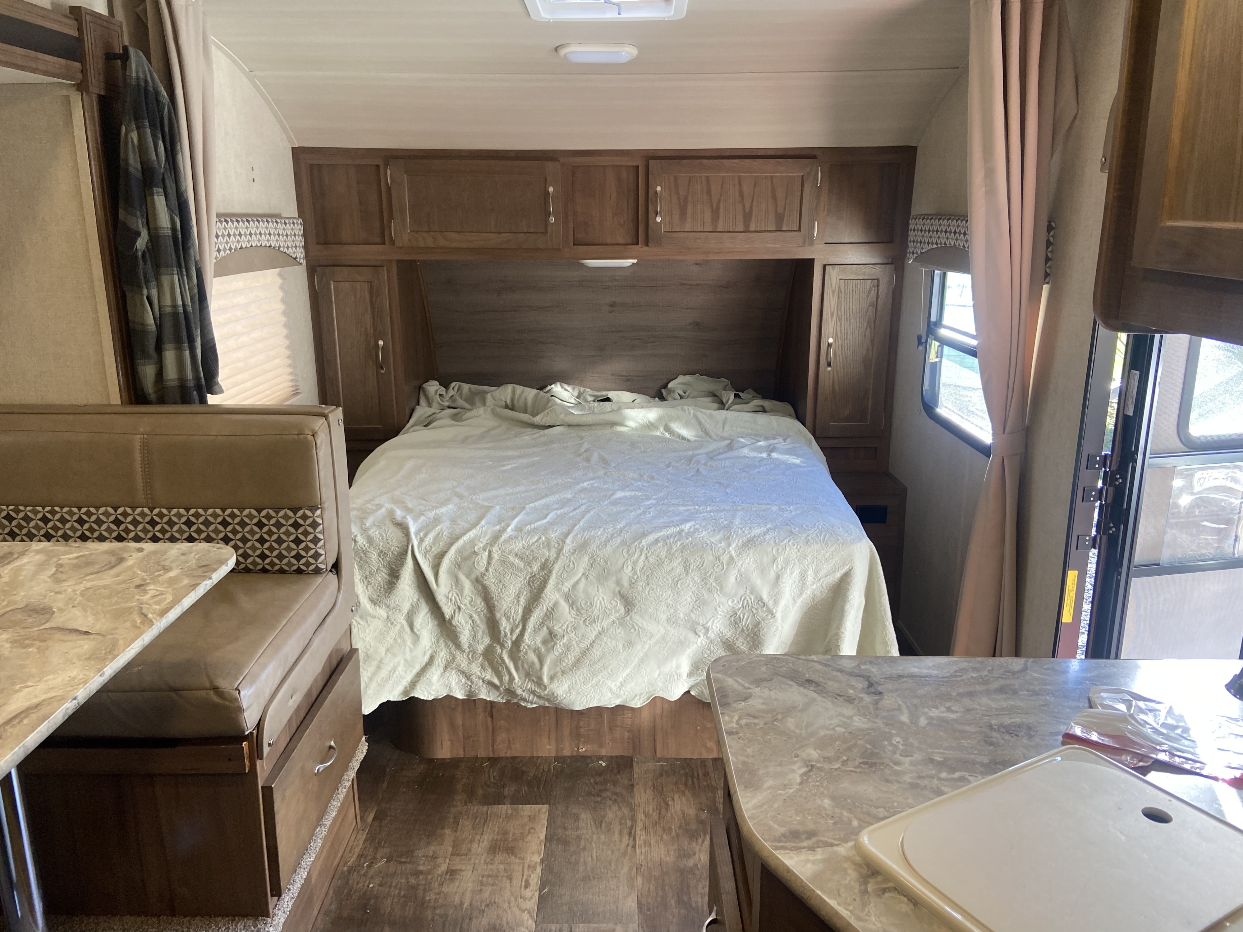 Cozy RV rental interior showing a comfortable bed, functional dinette, and compact kitchen counter.. Gulf Stream Vintage Cruiser 2021