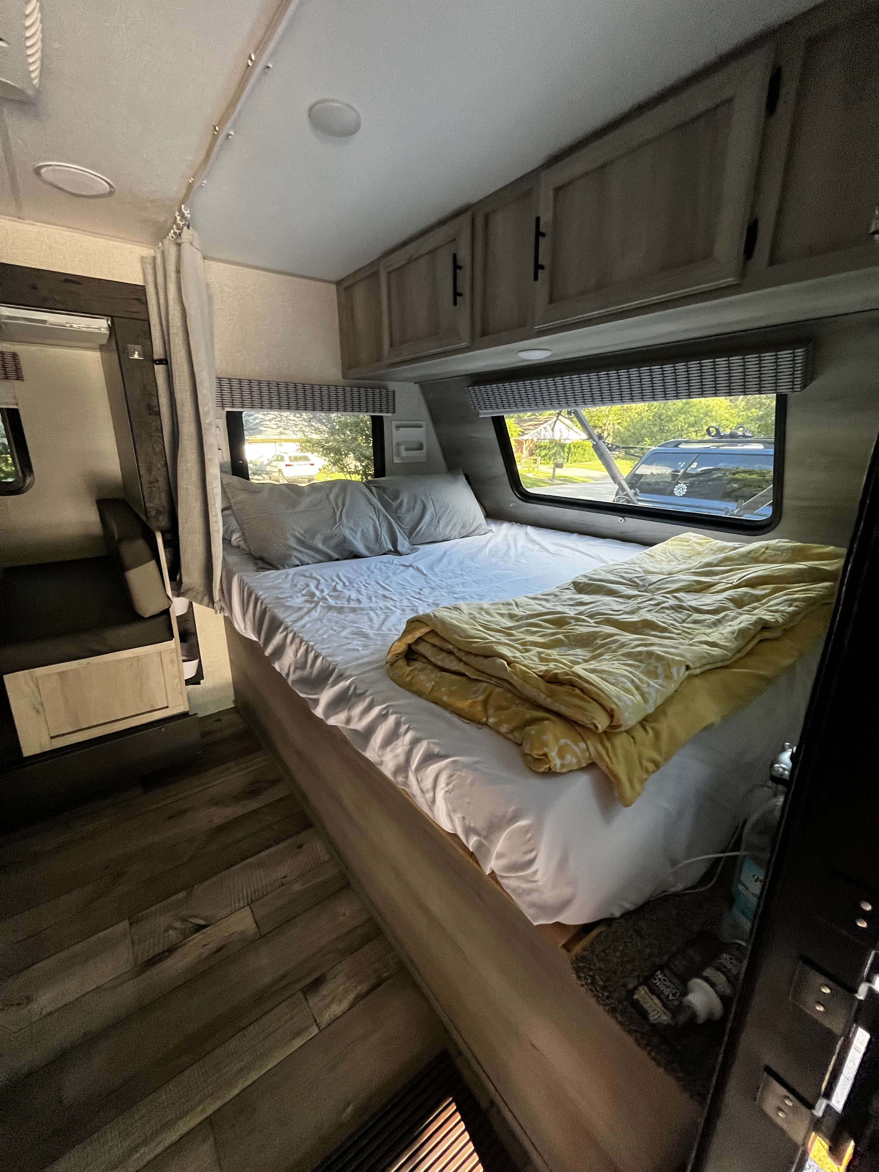 Relax in this RV rental's comfortable bedroom. Features a large bed, windows with natural light, and ample storage.. KZ Sportmans Classic 191bhk 2021
