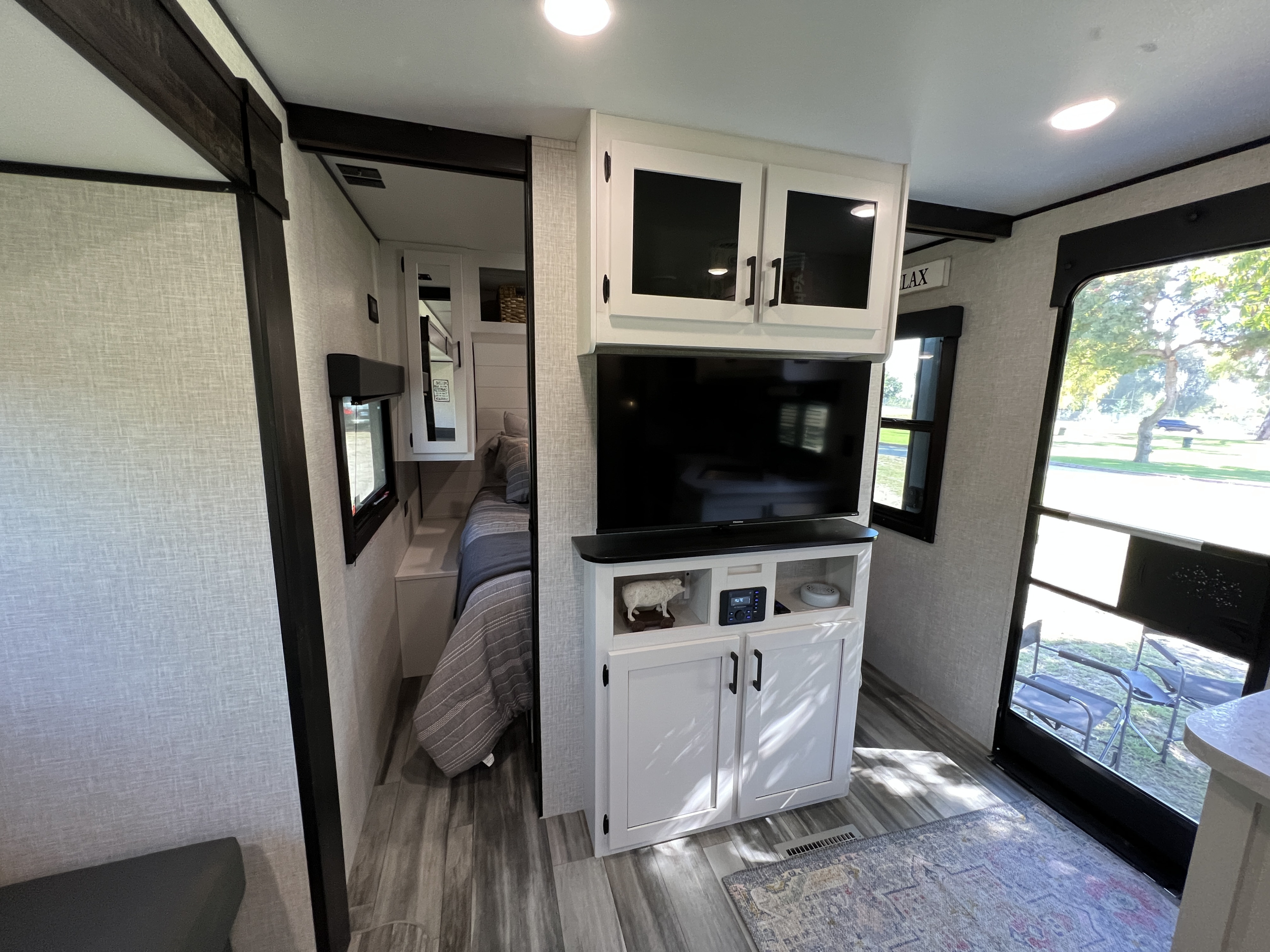 This RV rental interior offers a modern living space with a cozy bedroom, entertainment center, and stylish finishes.. Jayco 265BHS 2024
