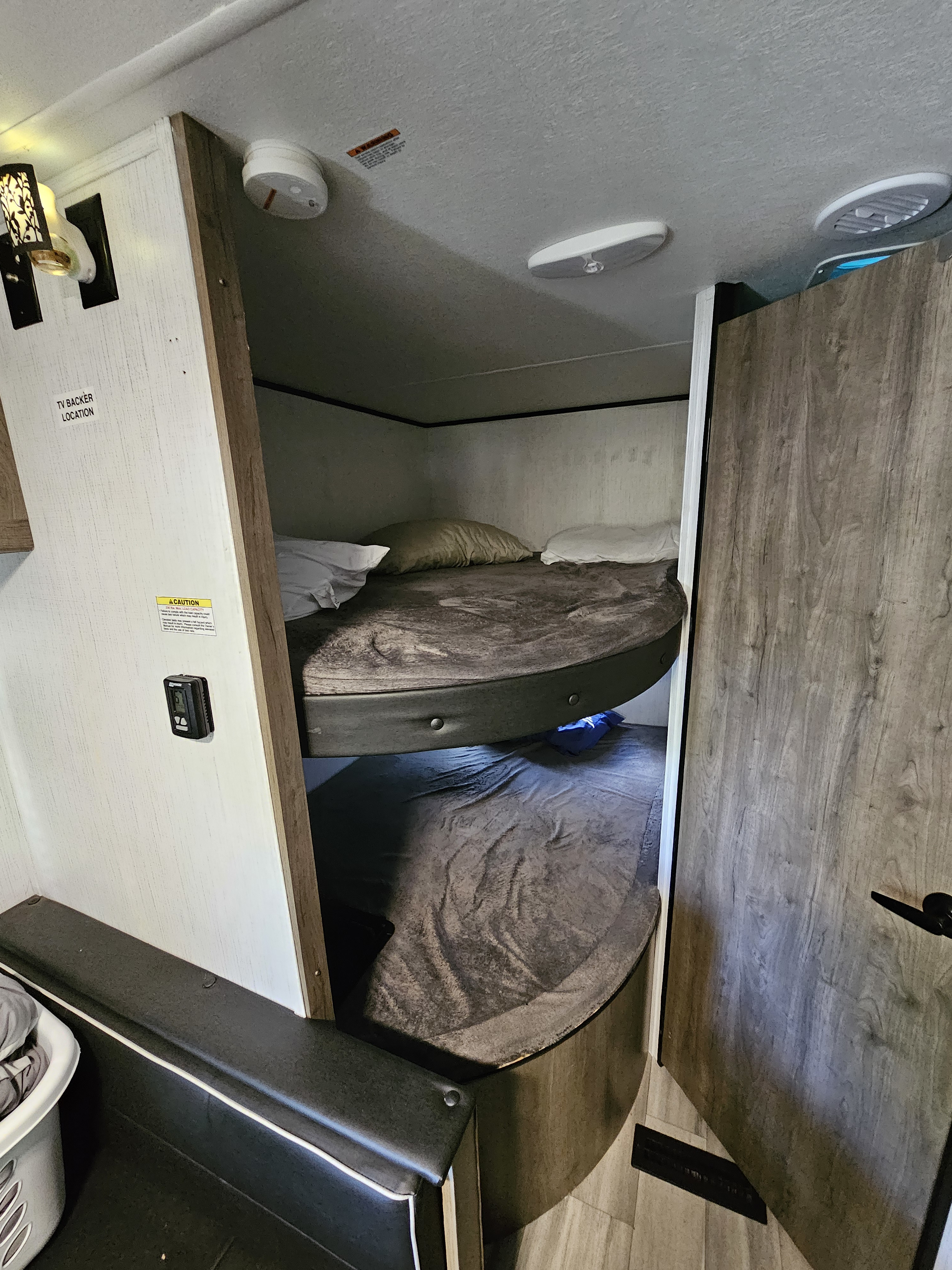 Experience comfort in this RV rental's bunk bed area, featuring cozy upper and lower berths with ample lighting and air vents.. Heartland RVs Pioneer 2022