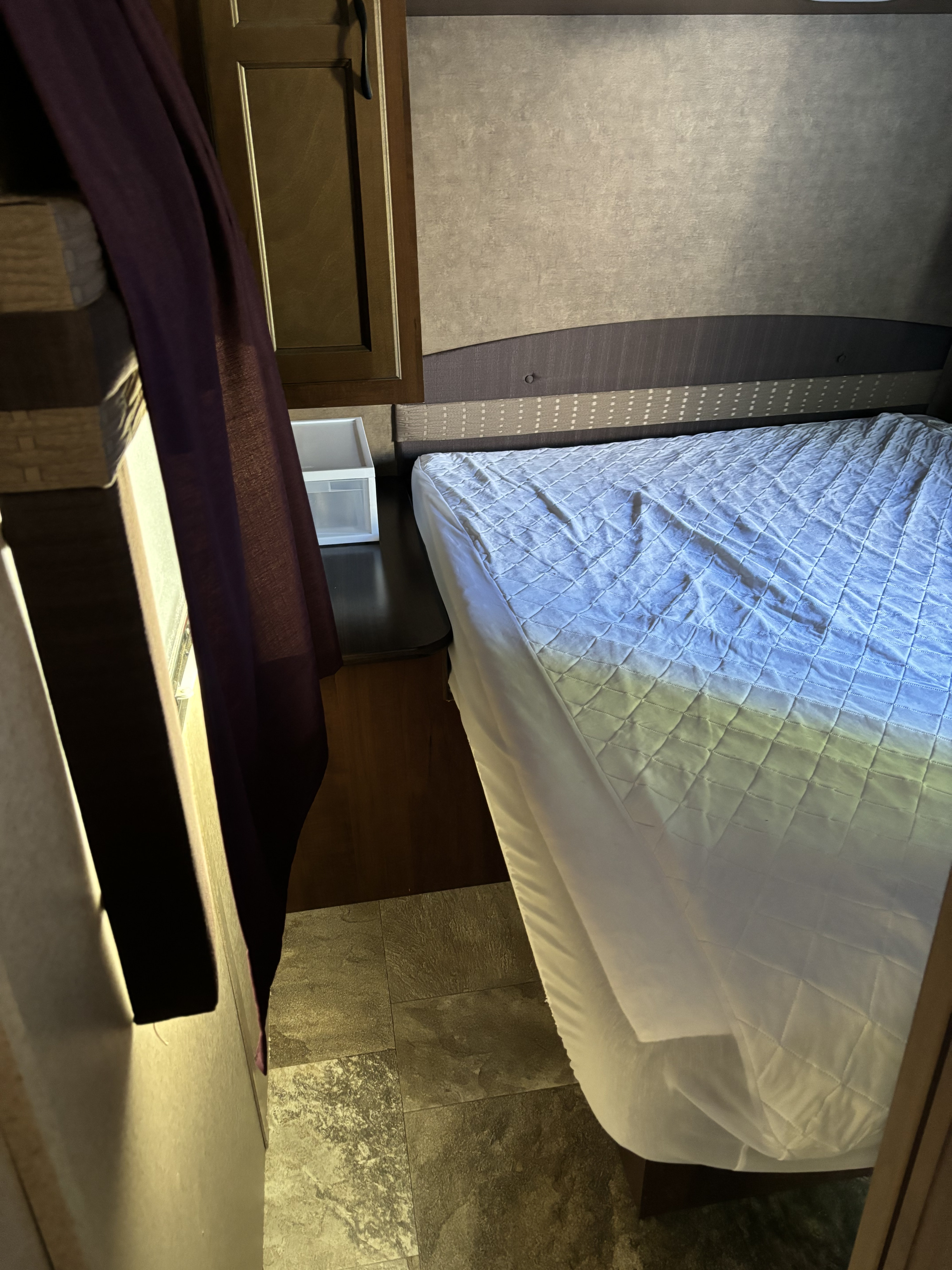 RV rental: compact bedroom with quilted bed, headboard, wood cabinets, and purple curtain.. Jayco Jay Flight 2015
