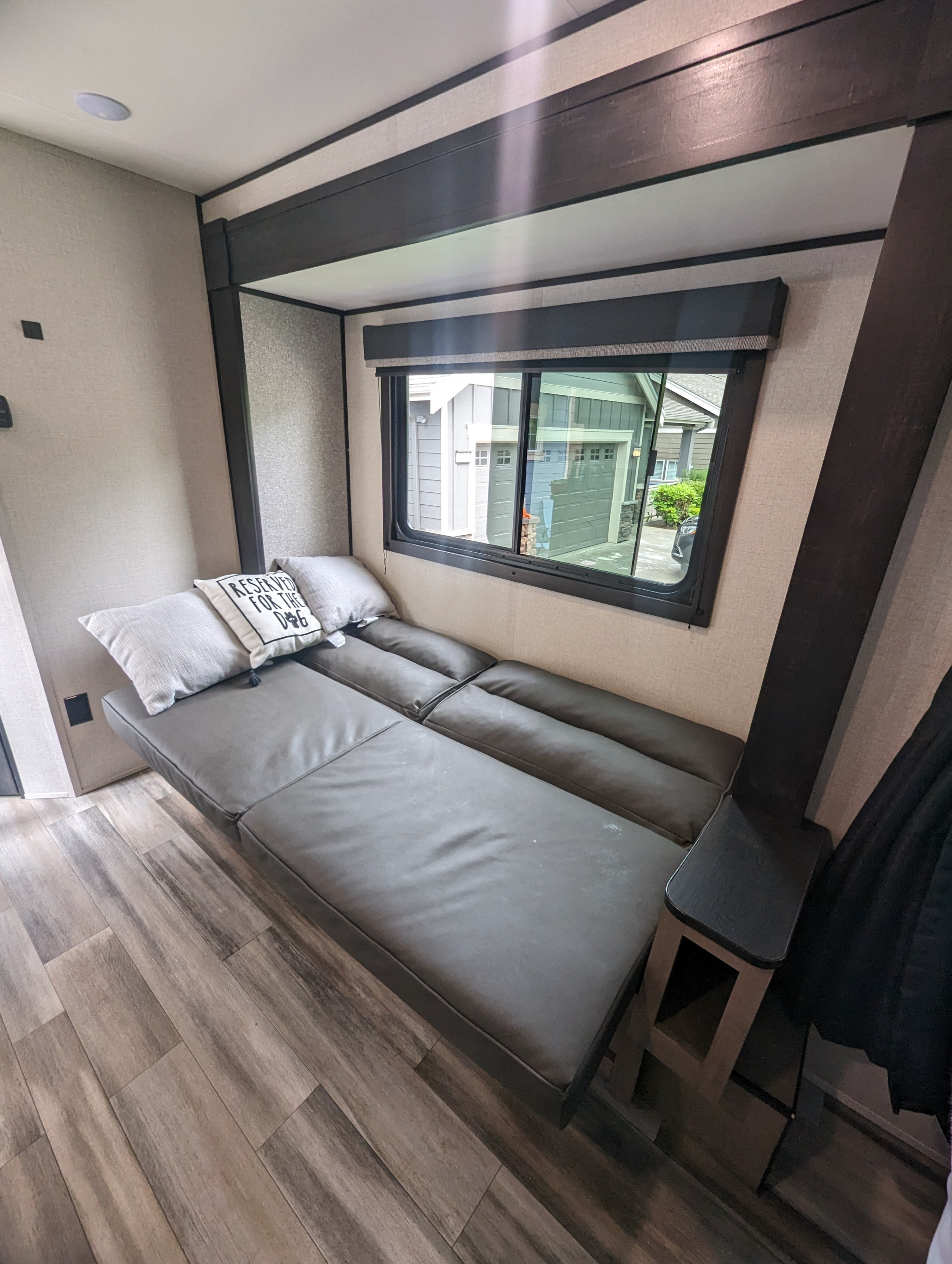 Comfortable RV rental interior featuring a versatile sofa bed, large window view, and modern wood-look flooring.. Highland Ridge RV Open Range 2022