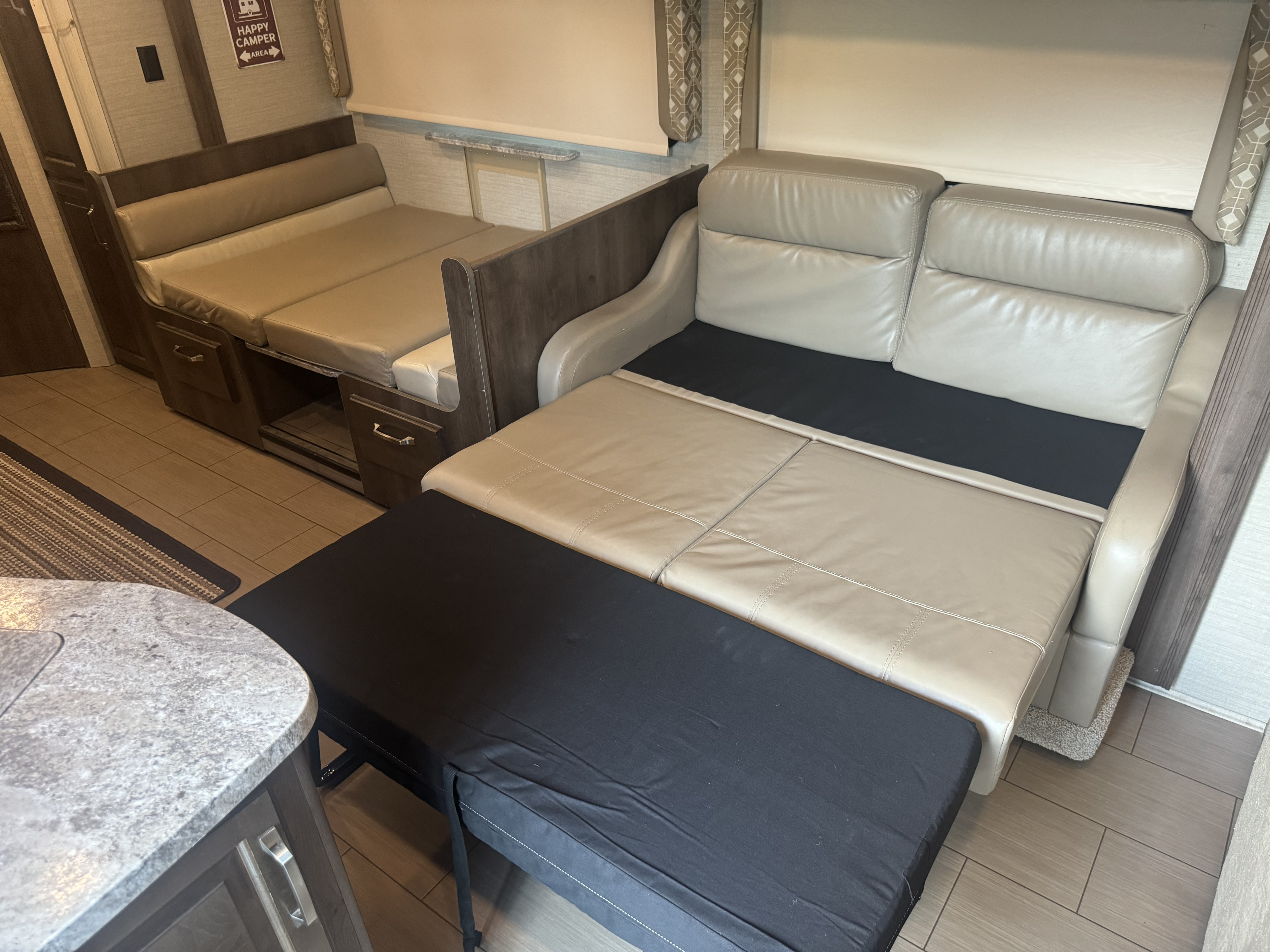 RV rental interior featuring a beige dinette and sofa, both convertible into beds for versatile sleeping arrangements.. Jayco Greyhawk 2019